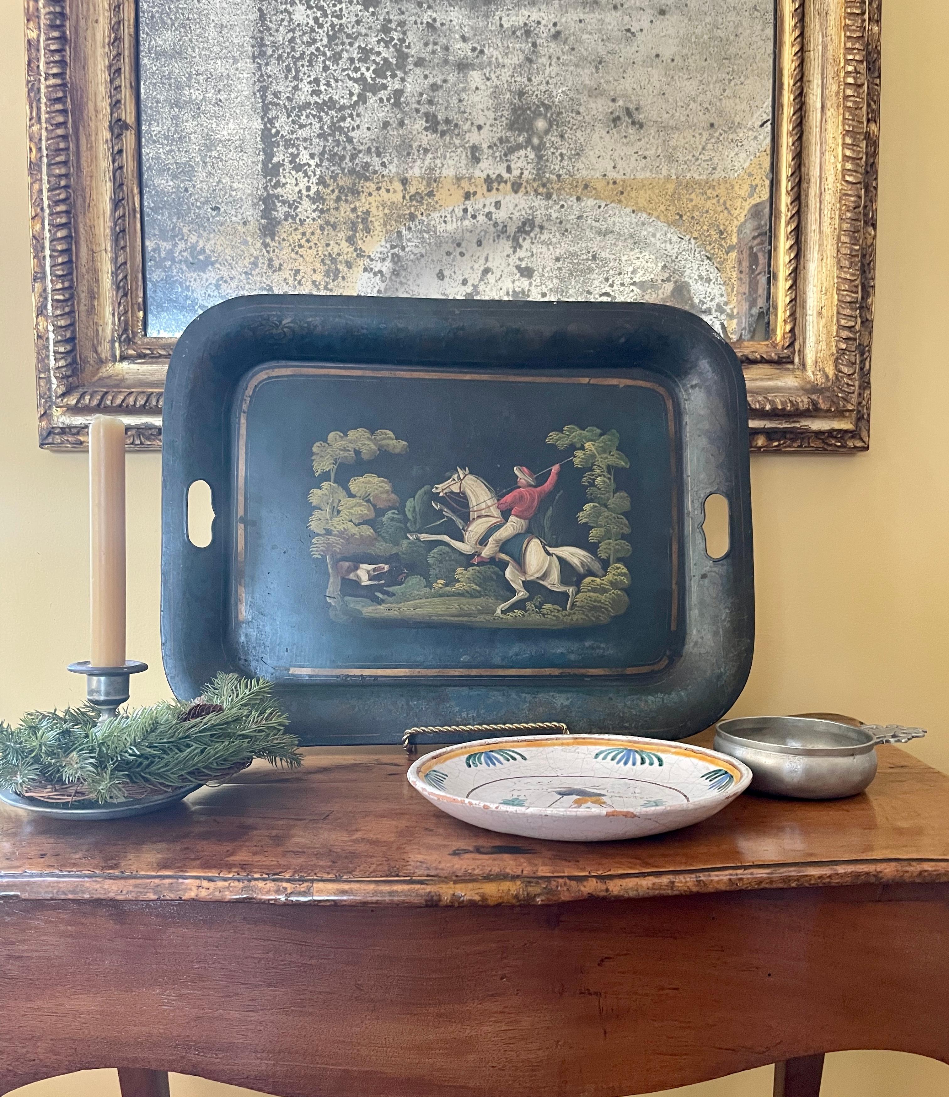 Italian hunting tray. Antique painted tole tray in black with rich steel blue overtones and gilt banding centering an oriental hunting scene featuring a turbaned hunter on horseback in rich red cloak with raised spear and rearing horse before his