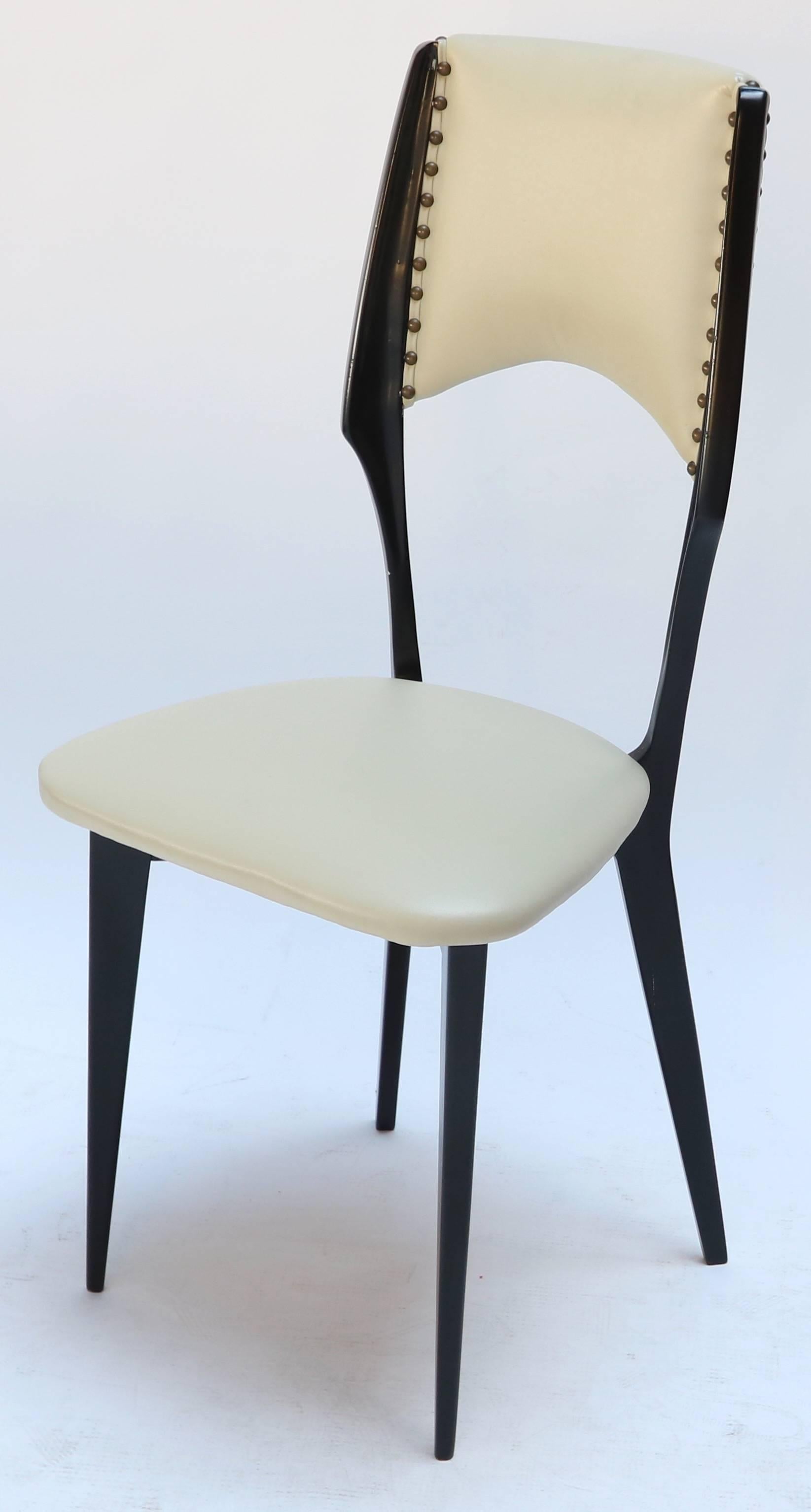 Set of ten 1960s Italian ebonized wood dining chairs in the style of Ico Parisi, circa 1962-1964, upholstered in beige leather with decorative brass studs.
