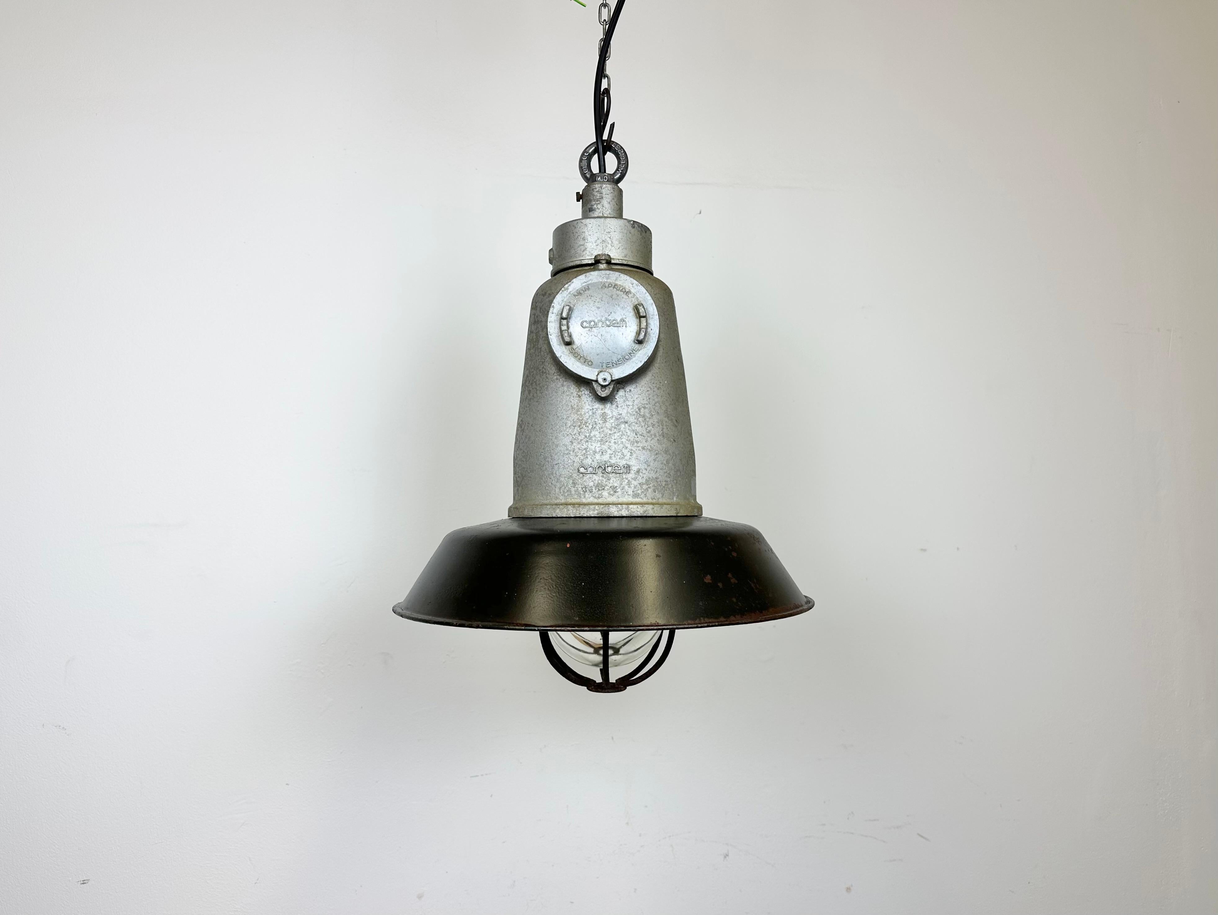 Large industrial factory hanging lamp made by Cortem Milano in Italy during the 1960s. It features a cast aluminium top, a black enamel shade with white enamel interior,a clear glass cover and an iron grid. The porcelain socket requires E 27/ E26