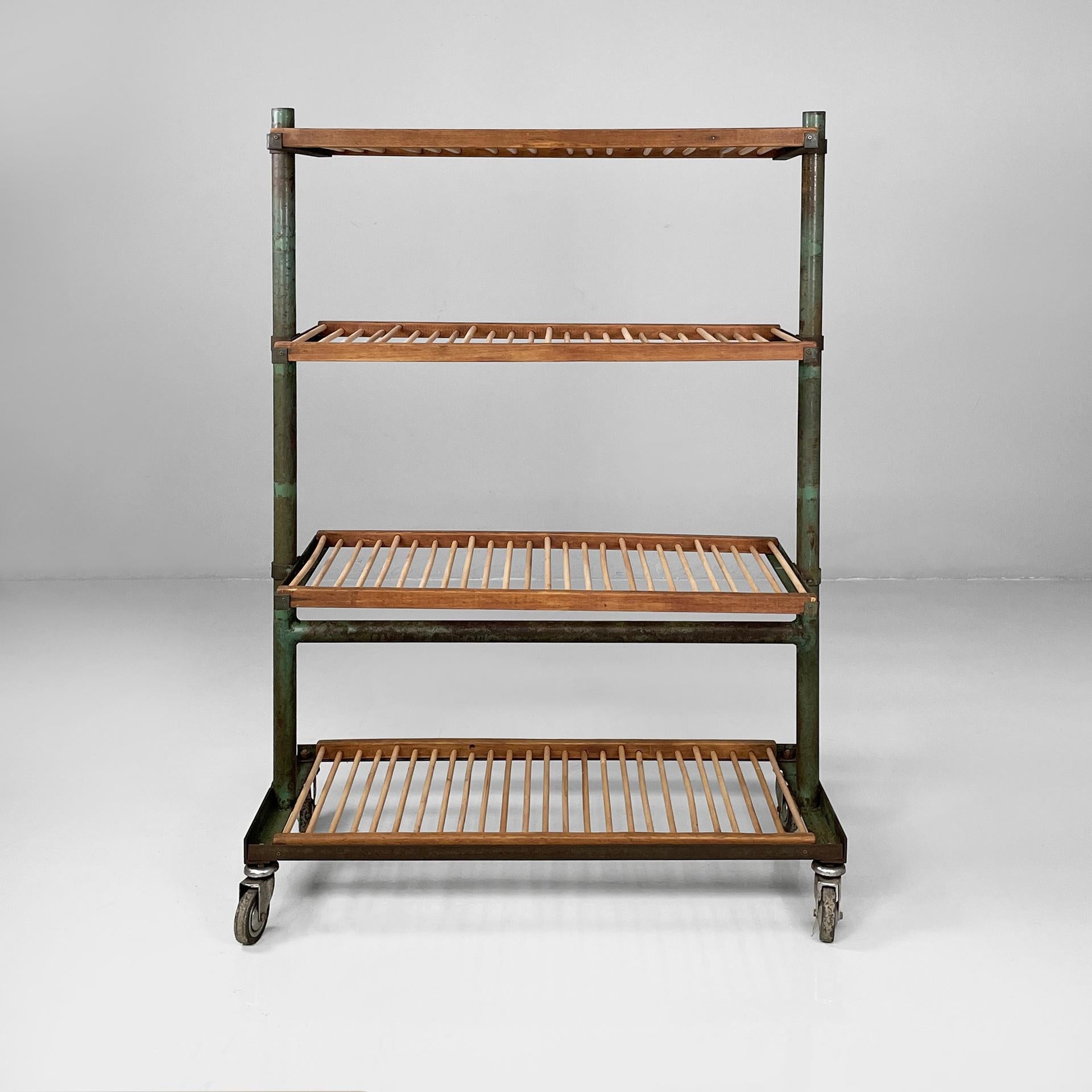 Italian industrial cart in wood and green metal, 1920s
Fantastic and vintage cart with four shelves in wood and green painted metal. Each shelf is composed of a series of round section slats, embedded in two horizontal square section slats. The