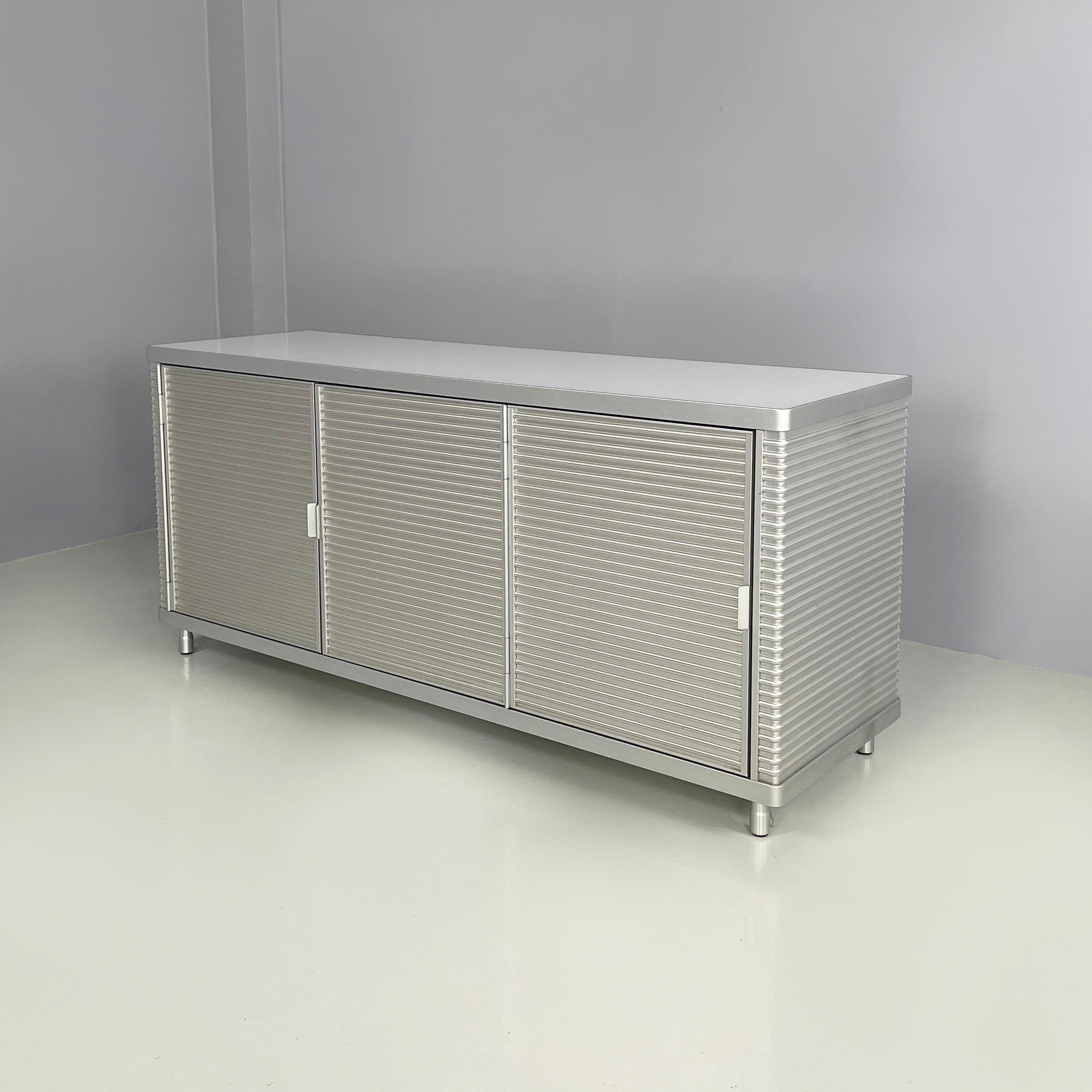 Italian industrial modern Aluminum and glass sideboard  by Ycami, 1990s
Sideboard with rectangular base and rounded corners, in aluminum and glass. The top is made of glass, while the structure is made of aluminum with a horizontally knurled