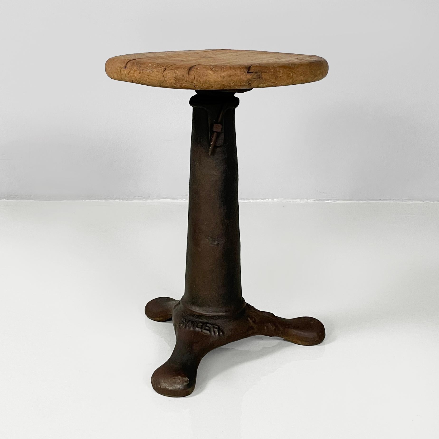 Italian industrial wood and cast iron stool by Singer, 1930s 
Stool with round wooden seat. Cast iron conical base with three legs.
Produced by Singer in 1930s. Logo imprinted on the base.
Vintage condition. The wood has various signs of aging. The
