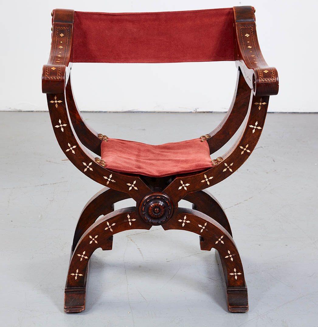 An “X”-frame folding chair with curved arms and legs joined by a central working pivot and standing on sled feet. In walnut with good rich color and bone inlay decoration. Substantial presence. Italian, circa 1700. These chairs are sometimes