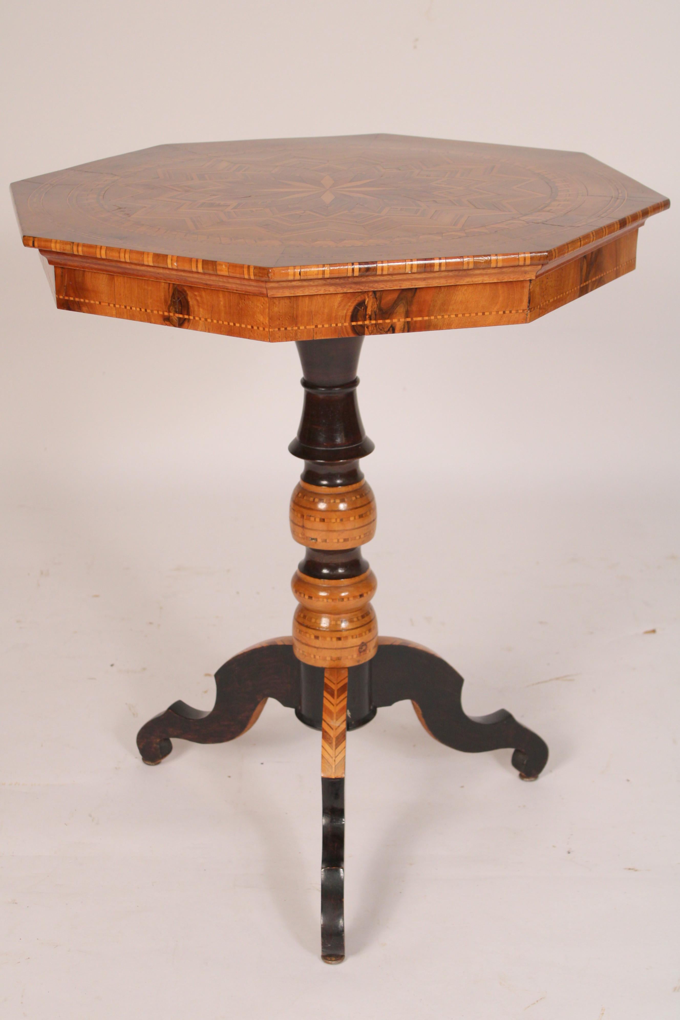 Italian inlaid octagonal shaped occasional table, circa 1930's. With a octagonal shaped top with exotic wood inlays, including birch, rose wood, fruitwood and approximately 3 or 4 more type of woods, a turned pedestal with black lacquer and wood