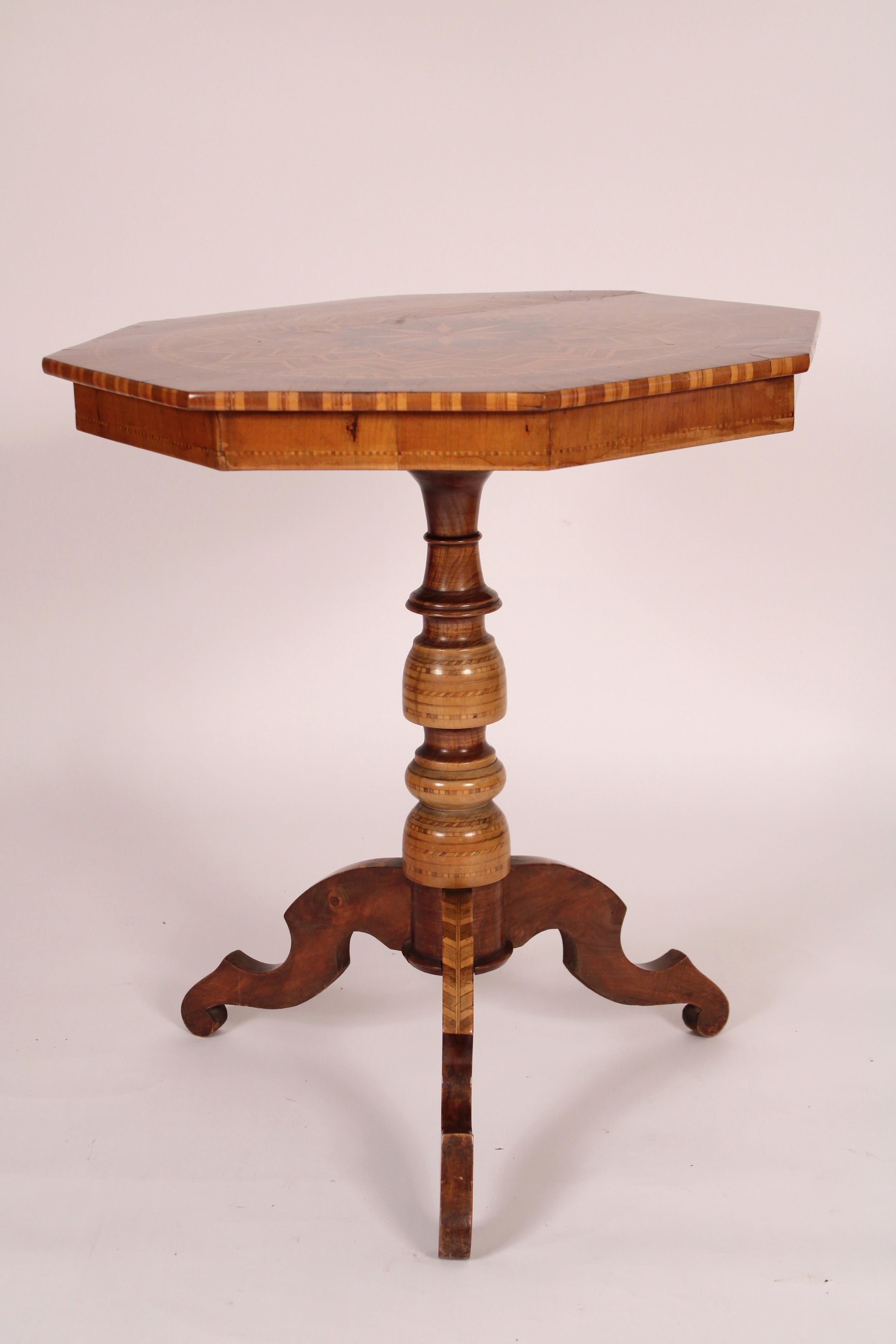 Italian inlaid octagonal shaped side table with extensive inlay, circa 1930's. With a octagonal shaped top with exotic wood inlays, an inlaid and turned pedestal with 3 inlaid down swept legs. The legs are dove tailed into the pedestal.