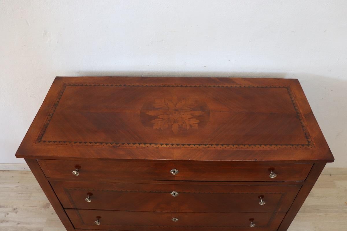 20th century Italian superb chest of drawers, circa 1960s. In perfect high quality Louis XVI style characterized by a refined floral decoration inlaid in walnut wood. The decoration can be admired on each side of the furniture. Chest of drawers
