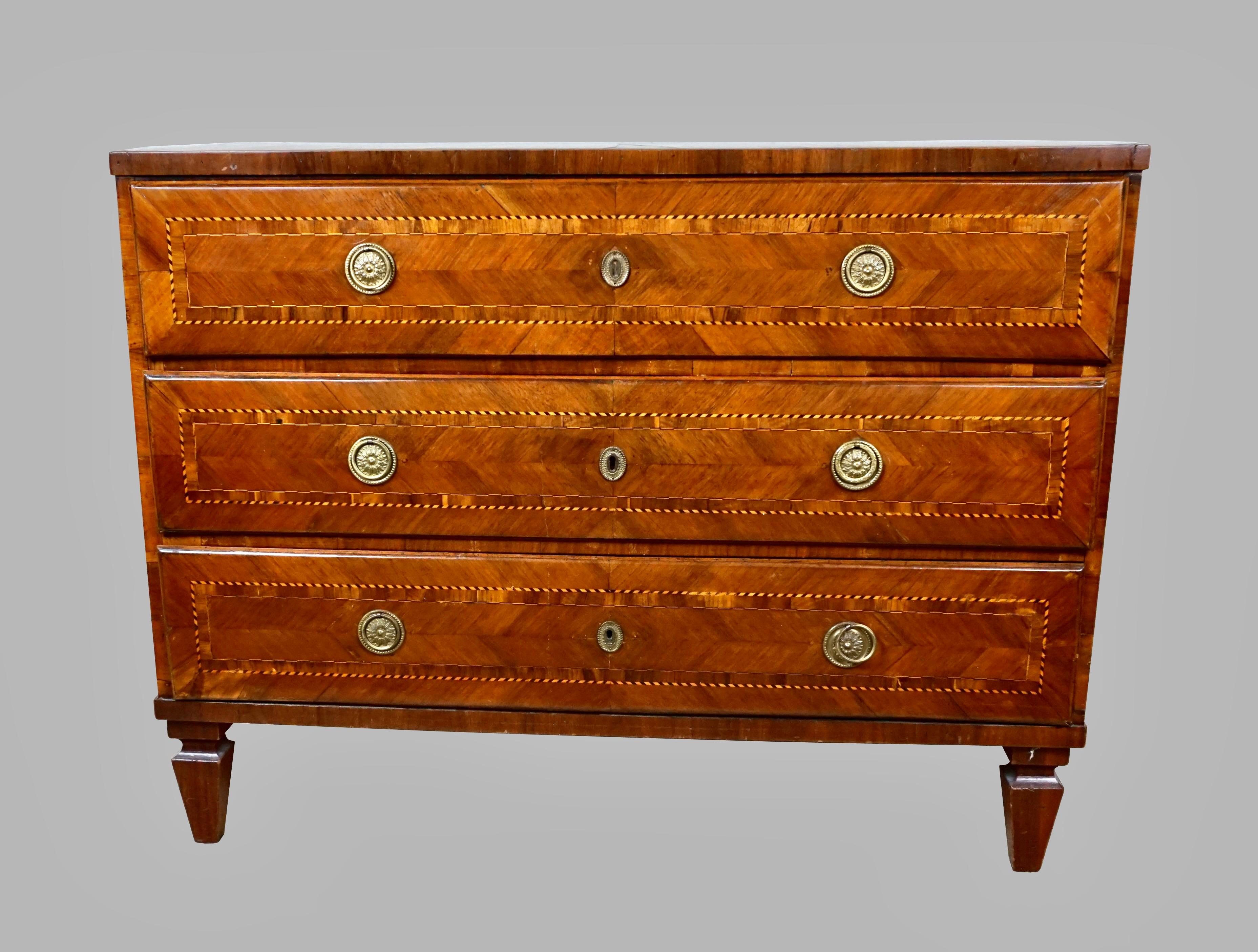 A substantial and handsome Italian walnut veneered Neoclassical 3 drawer chest, each drawer with attractive boxwood and ebony banding, further decorated with chevron veneered insets and framing of the entire drawer. The top and sides are similarly