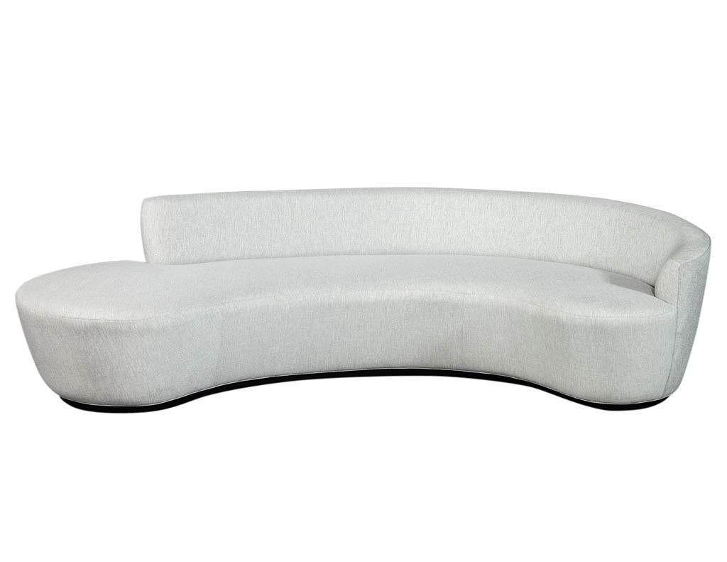 Italian Inspired Modern Designed Curvaceous Sofa Custom Made by Carrocel. Upholstered in a Designer Luxurious Silvery grey Fabric, Perched on a Charcoal Lacquered Base.