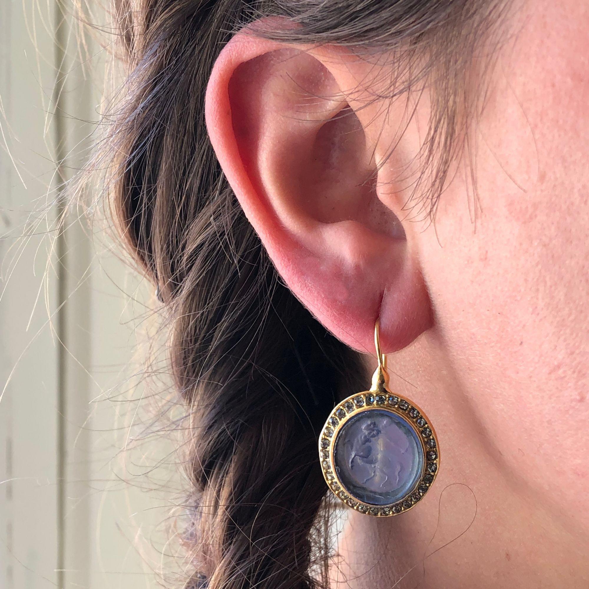 For pierced ears.
Lever- back earrings in vermeil, silver covered with yellow gold.
These antique style earrings have an intaglio on blue glass paste representing a centaur in an entourage of small crystals. The clip is a swan neck with safety