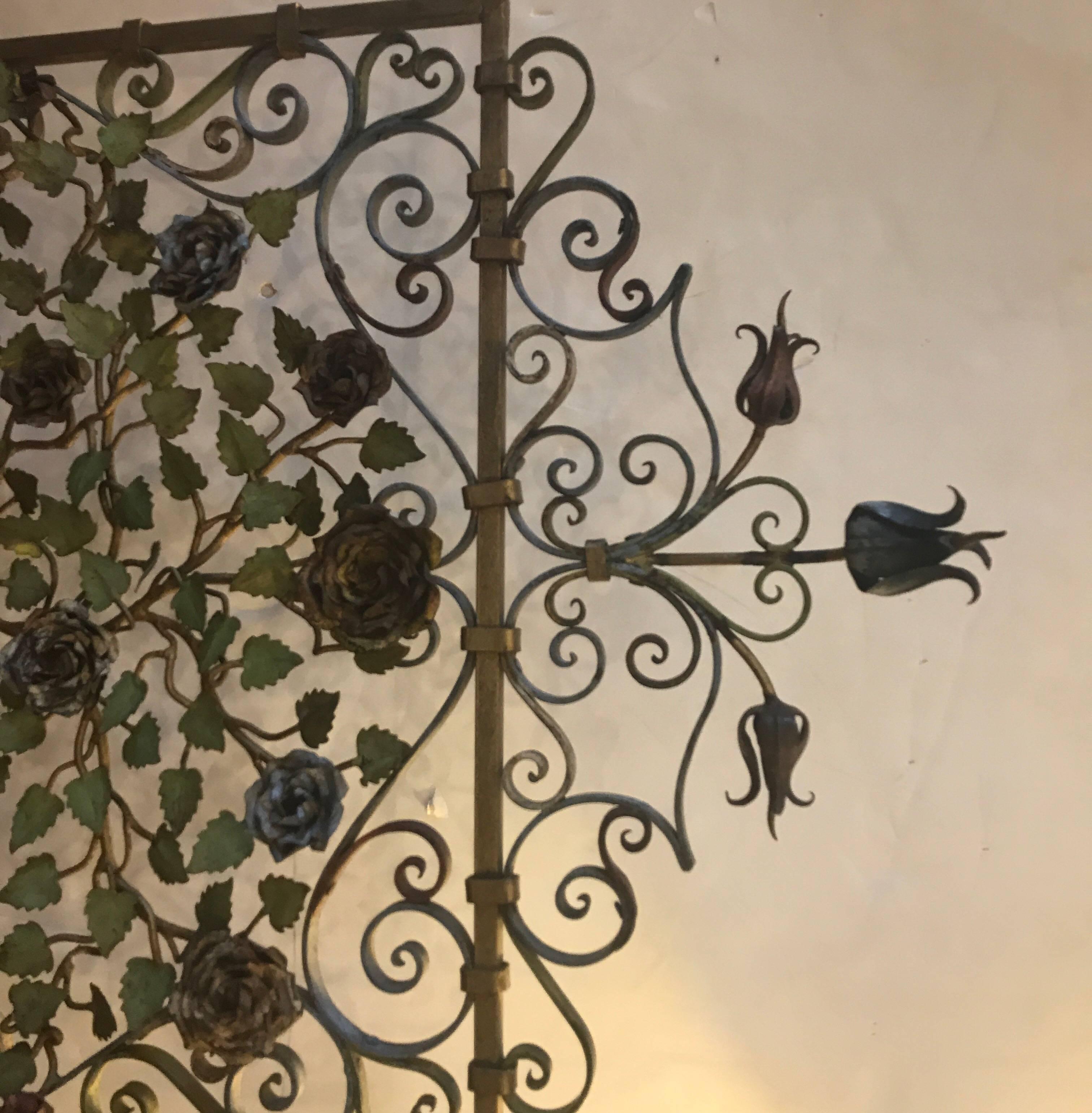 An early 20th century Italian iron on tole firescreen with original painted and gilt finish. The main body of scrolling wrought iron with a large floral applied display in hand-painted tole ware. The original finish is weathered and warm.