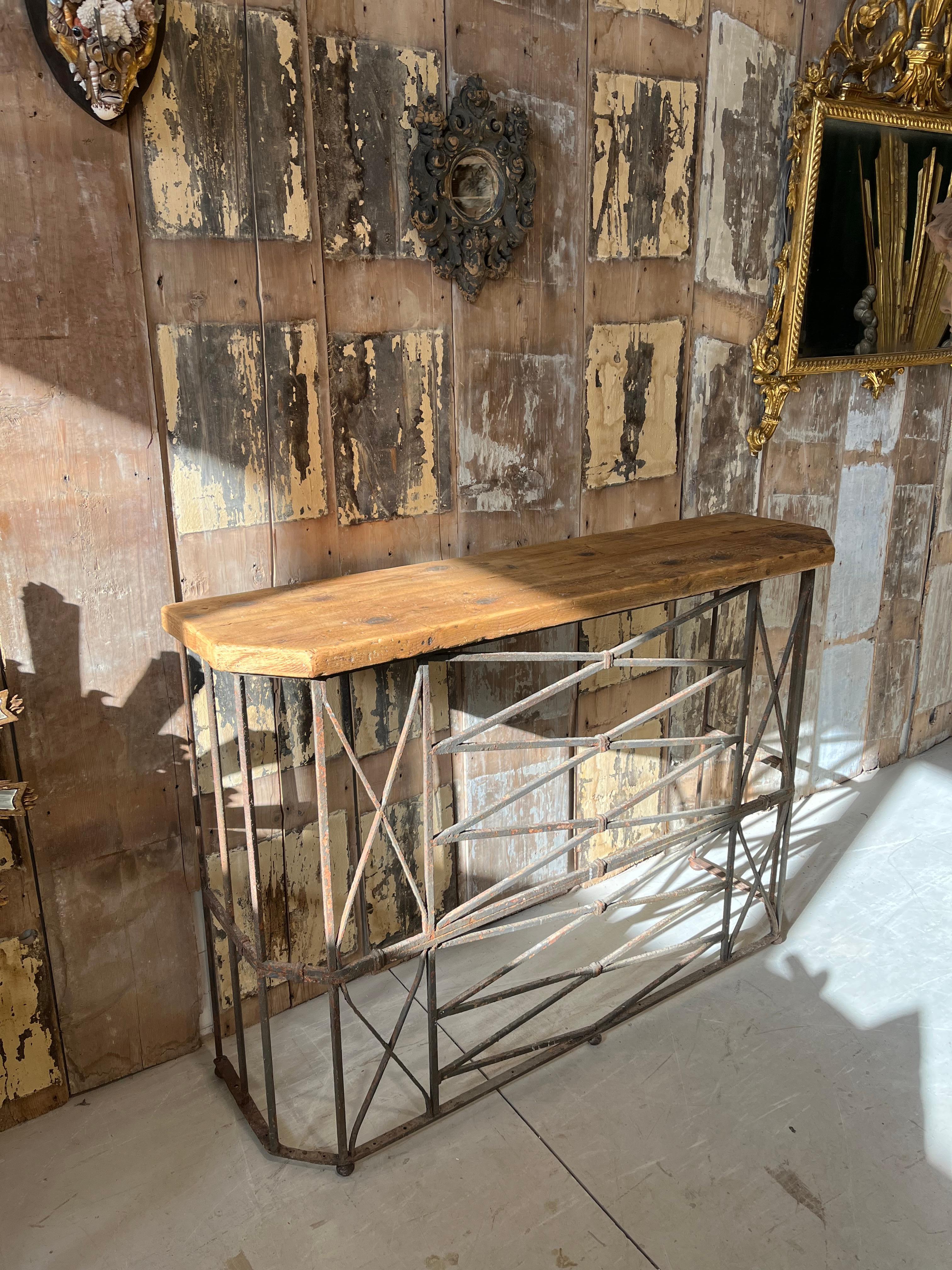 Early twentieth-century iron notched balcony, converted into a console by adding a shaped top made of fir (reclaimed wood) with a natural finish. Original patina in the iron part.