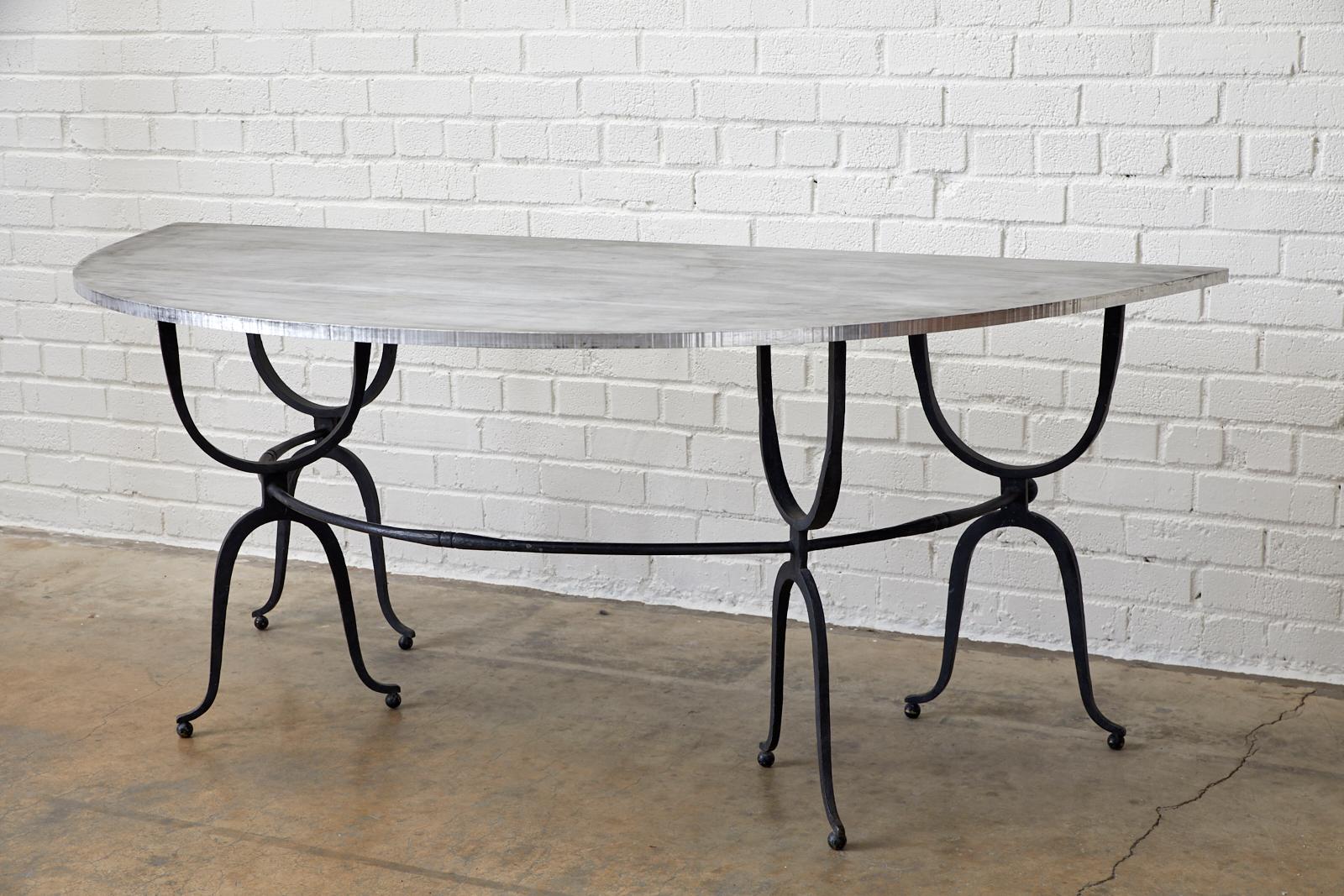 Fantastic Italian demilune table having a newer steel top. Originally constructed as a hunt table or wine tasting table with a wood or marble top. The iron base is made of four pairs of supports conjoined by a curved rod. Elegantly curved legs