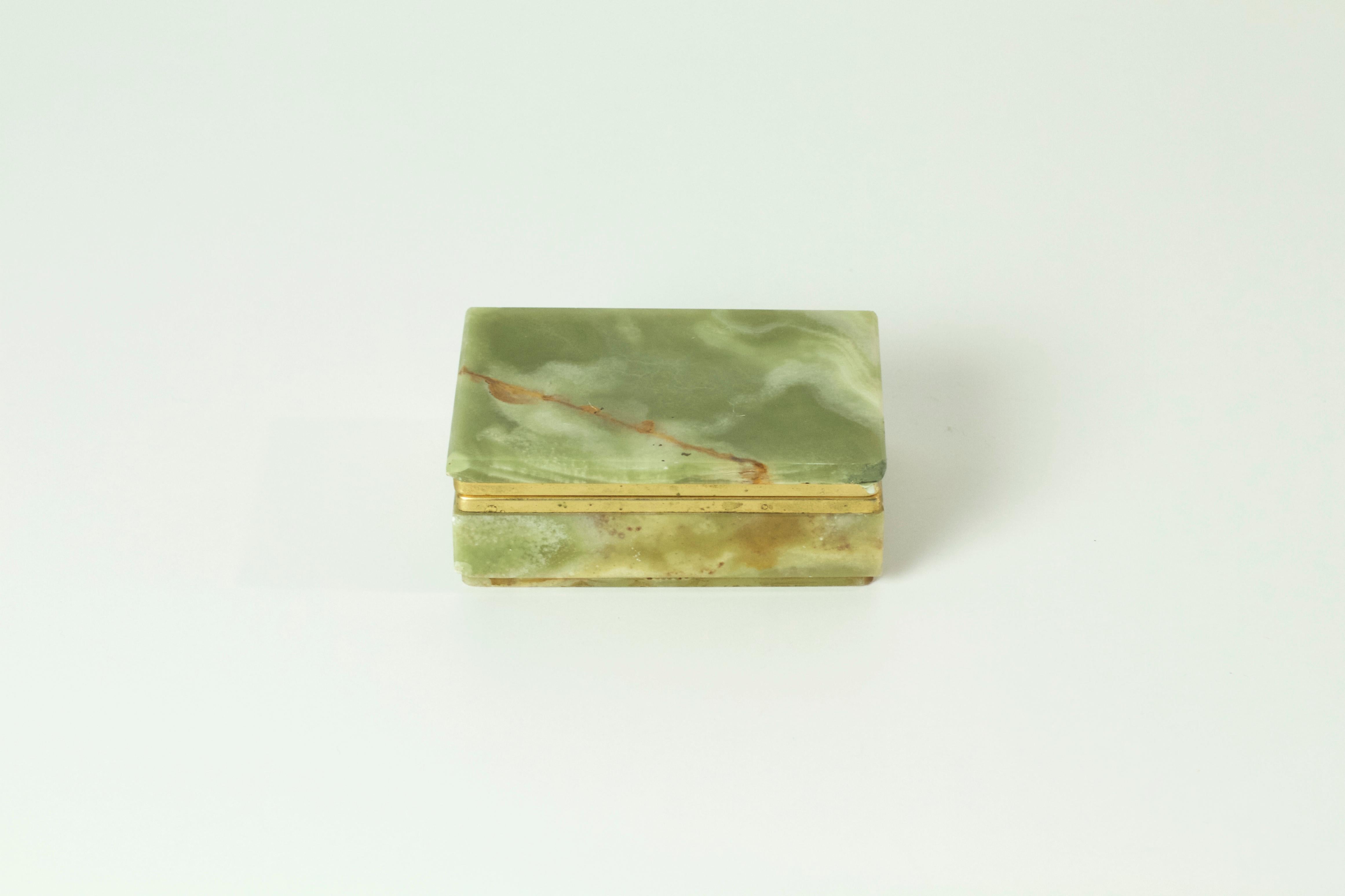 Trinket/jewelry box with a hinged lid made in Italy from Pakistani onyx and brass gilded in gold. The onyx has a range of all natural colors from brown to green which is seen in this piece as well. No chipping or cracks.