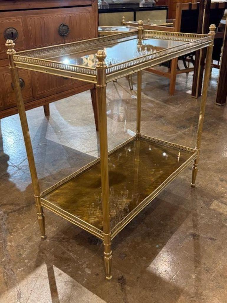 This Italian Jansen Manner brass side table with an eglomise mirrored top embodies a vintage/retro style, adding a touch of elegance and sophistication to any room. The mirrored top gives the piece a luxurious and reflective quality, while the brass