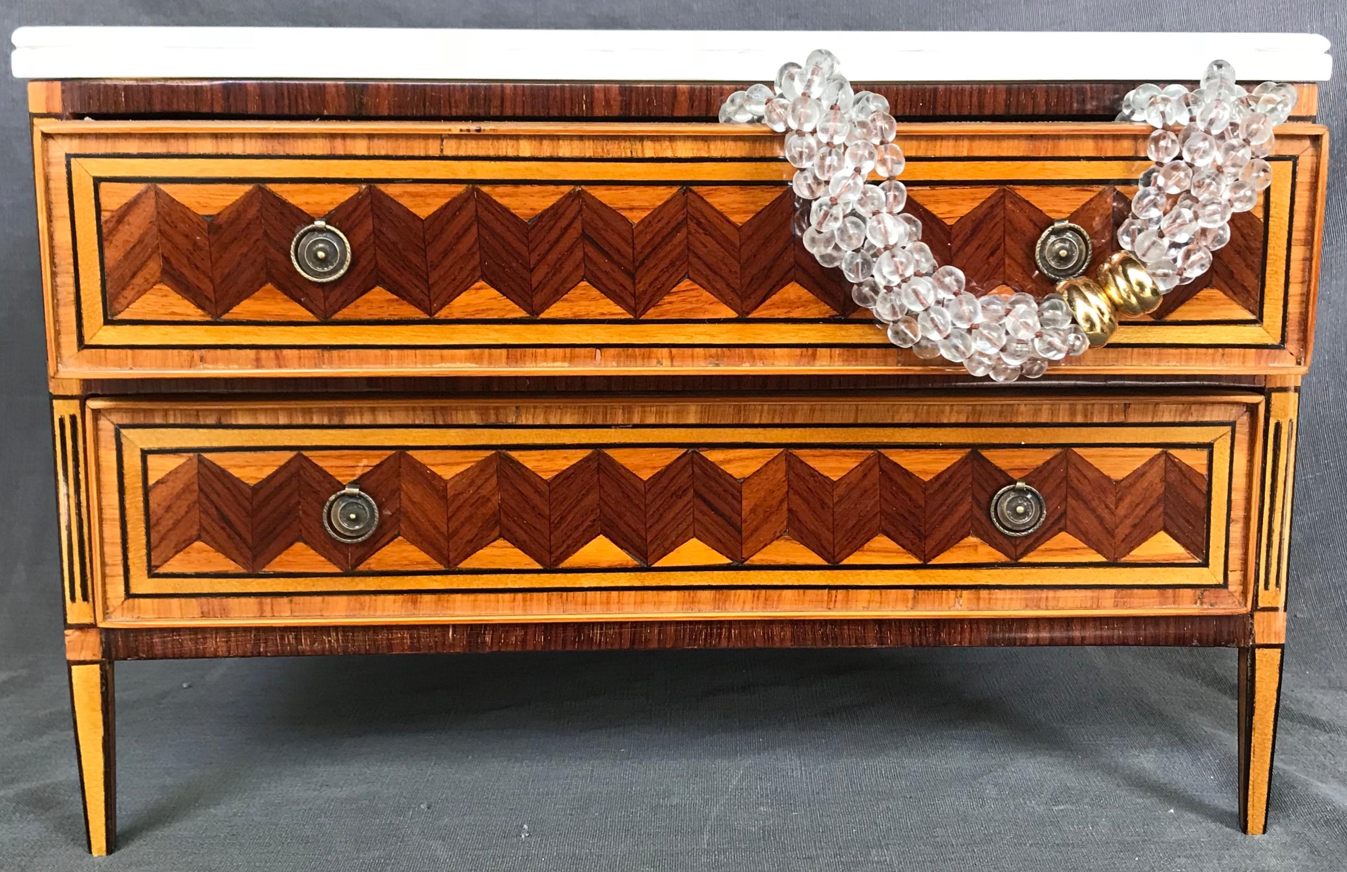 Italian jewelry box. Neoclassical style miniature chest of drawers fit for jewels.  A scaled replica of a Louis XVI boxwood, palissander, rosewood and ebony inlaid commode with antique Carrara marble top and velvet lined drawers finished on all