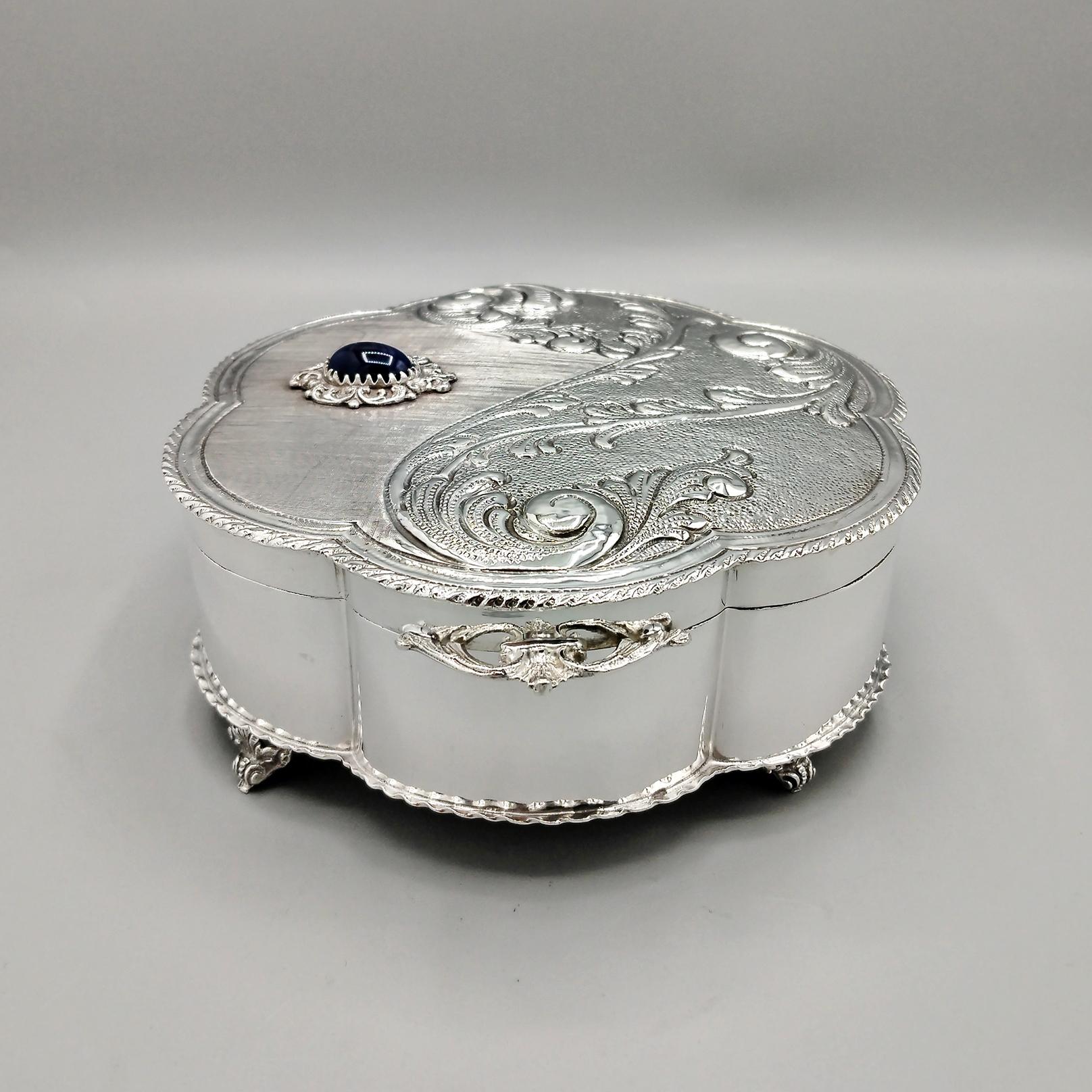 Italian jewelry box in solid 800 silver with hard stone made entirely by hand.
The body of the jewelry box is round and flower-shaped.
The hinged lid has been subjected to different types of handwork, engraving, knurling, small hammering and