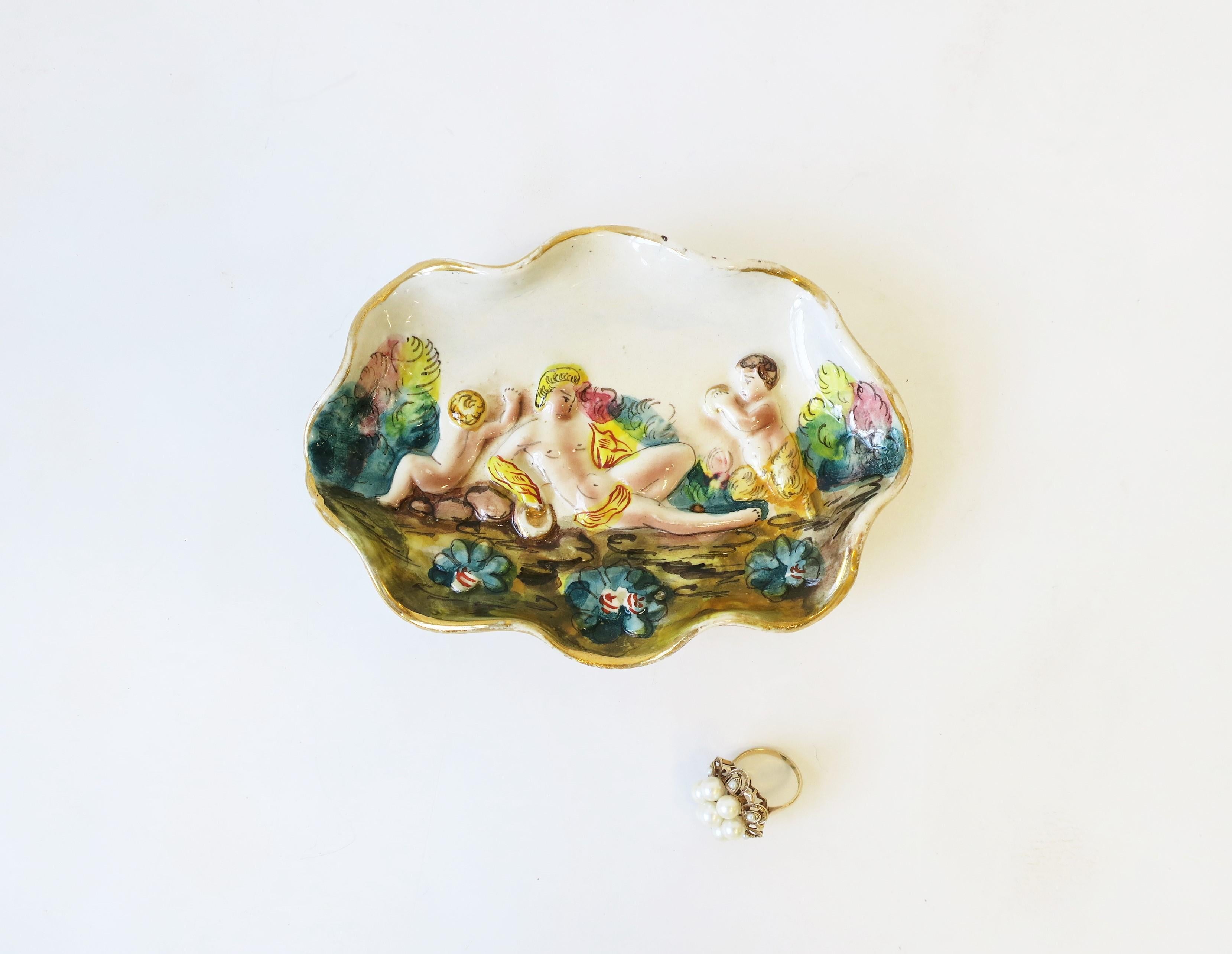 Italian ceramic jewelry dish with center male relief scene, ruffled edge with gold trim, circa 20th century. Made in Italy as marked in last image. A nice piece to hold jewelry or other small items on a desk or vanity area. Piece measures: 4.25