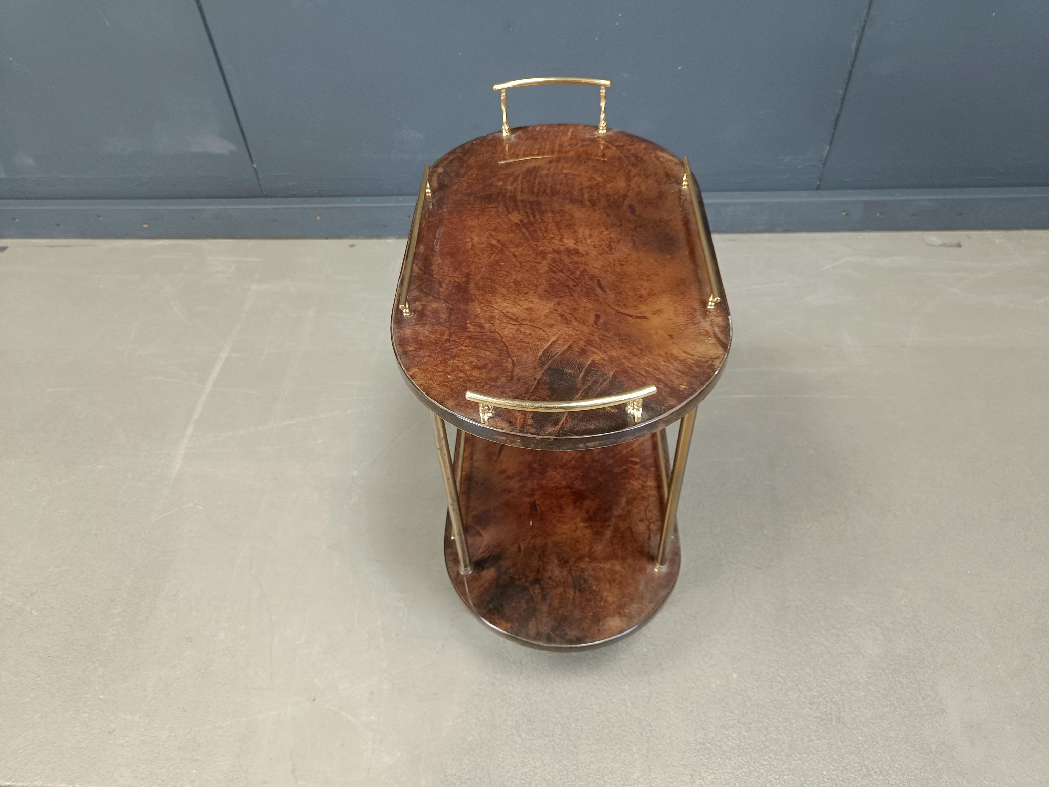 Chariot de bar Aldo Tura en peau de chèvre ou en parchemin. Ce chariot de bar a été fabriqué en Italie dans les années 1960. 

Fabriqué en peau de chèvre / parchemin épais et laqué, avec des accessoires en métal doré. 

Peut être utilisé comme