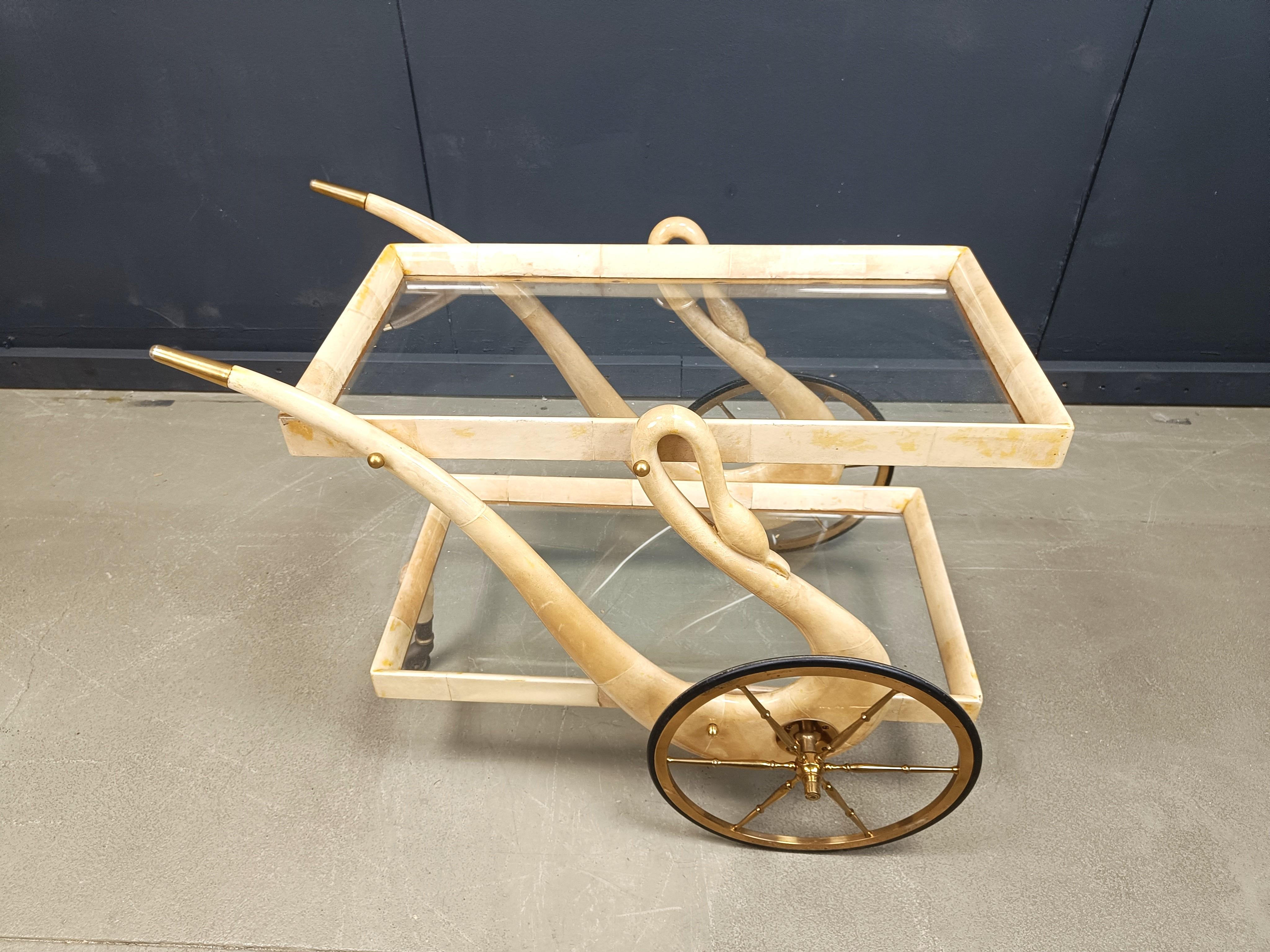 
Very rare Aldo Tura swan shaped Goatskin or parchment bar cart. This bar cart was made in Italy in the 1960s. 

Constructed of lacquered goatskin / parchment and brass hardware. 

Perfect bar or serving cart, or as rolling storage in an