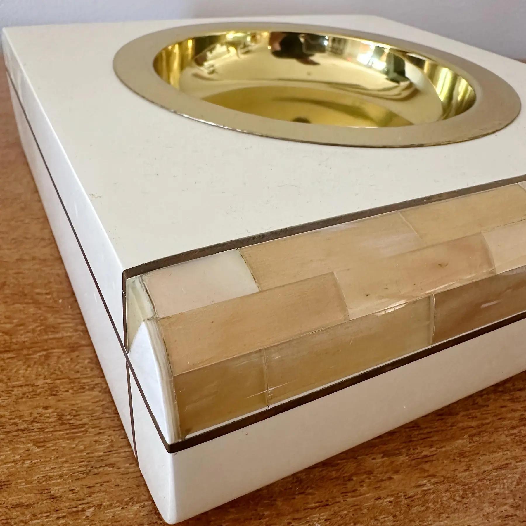 Colector lacado italiano, años 80. Cuerno teselado con incrustaciones de latón y bandeja de latón acabada en laca crema. Adecuado como cenicero, recogedor u objeto decorativo. Tres disponibles en distintos tamaños; consulta los listados para más