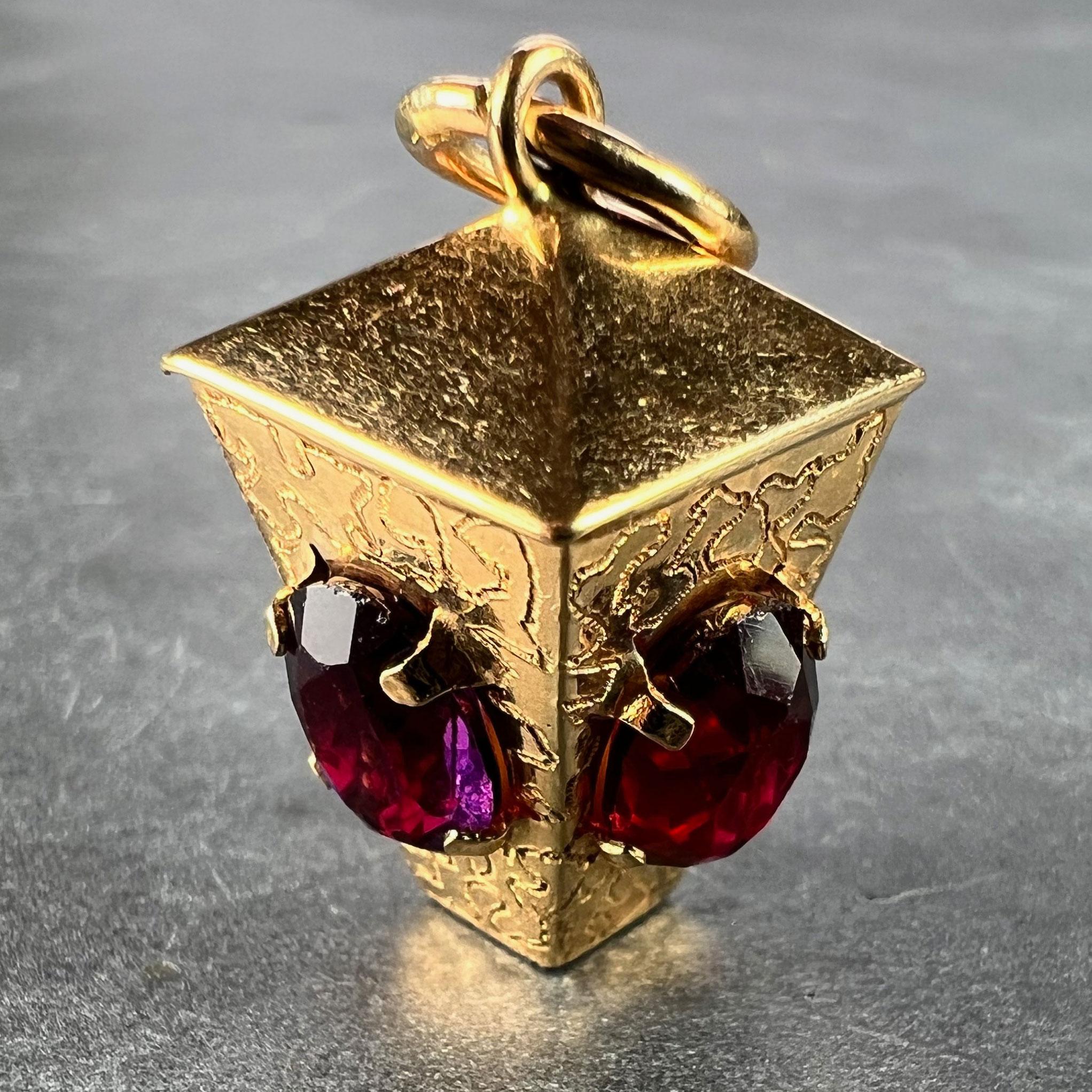 An Italian 18 karat (18K) yellow gold charm pendant designed as a square lantern with red and purple paste glass gems to the sides. Stamped to the jump ring with 750 for 18 karat gold and 31VA for Italian manufacture. 

Dimensions: 2.3 x 1.5 x 1.5