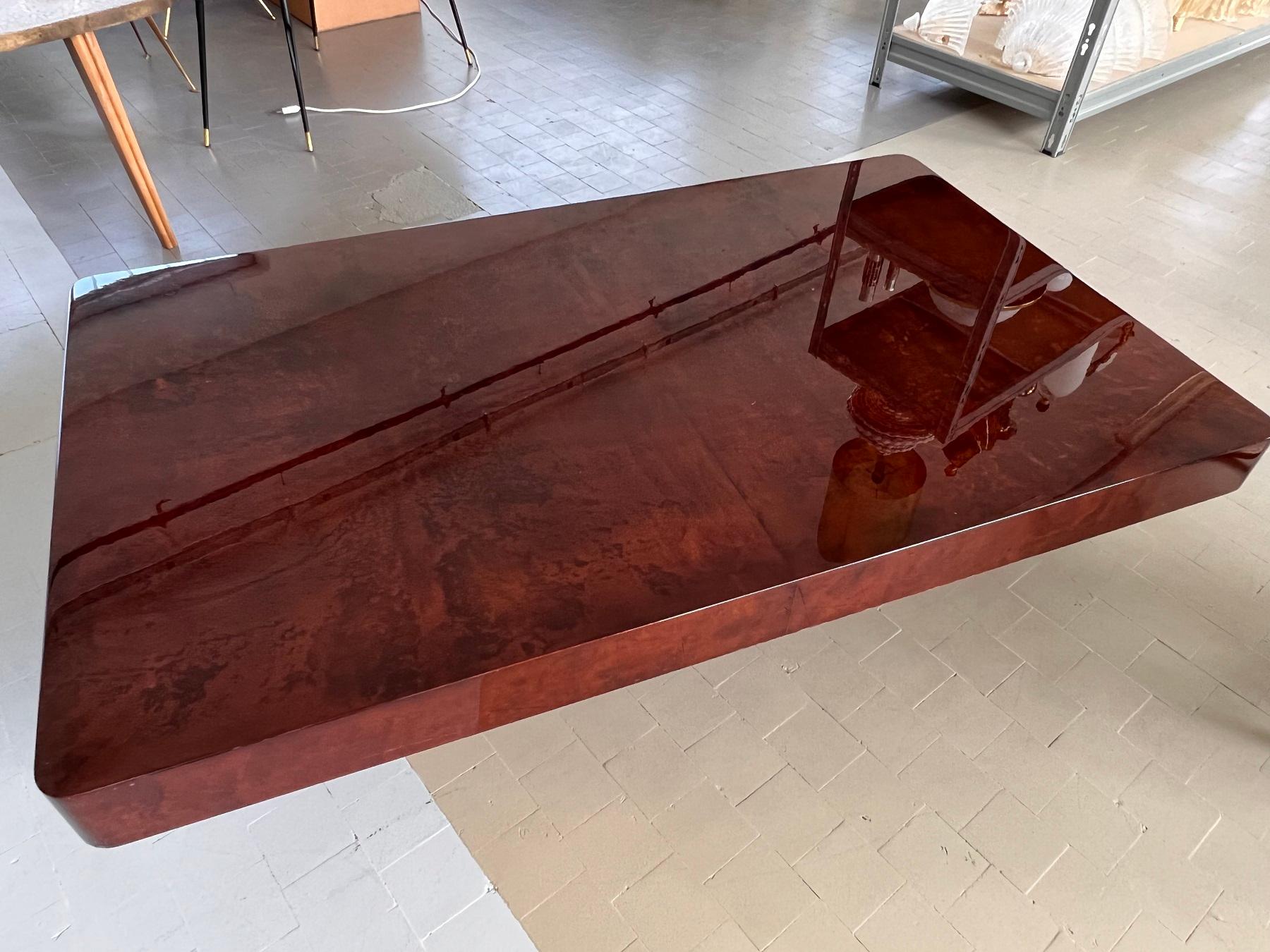 Exceptional, magnificent coffee table designed by Aldo Tura during the 1970s.
The table has been covered in red-brown-mahogany colored parchment paper and finished with a high gloss strong lacquer.  Beautiful statement piece, guaranteed to ignite