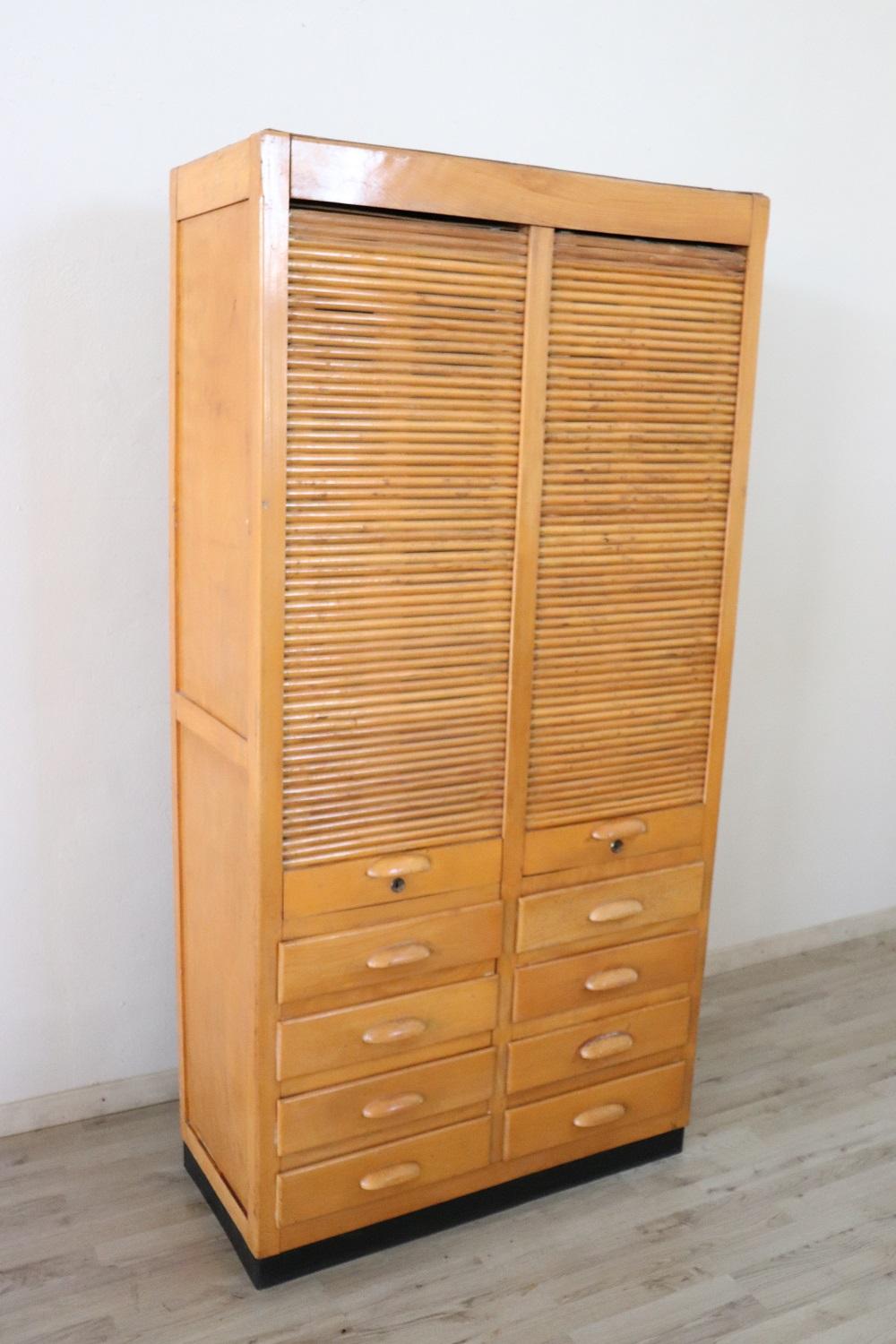 Italian cabinet, 1940s. High quality furniture in solid beechwood. The front doors has a handmade sliding shutter. Equipped with eight comfortable drawers in the lower part.