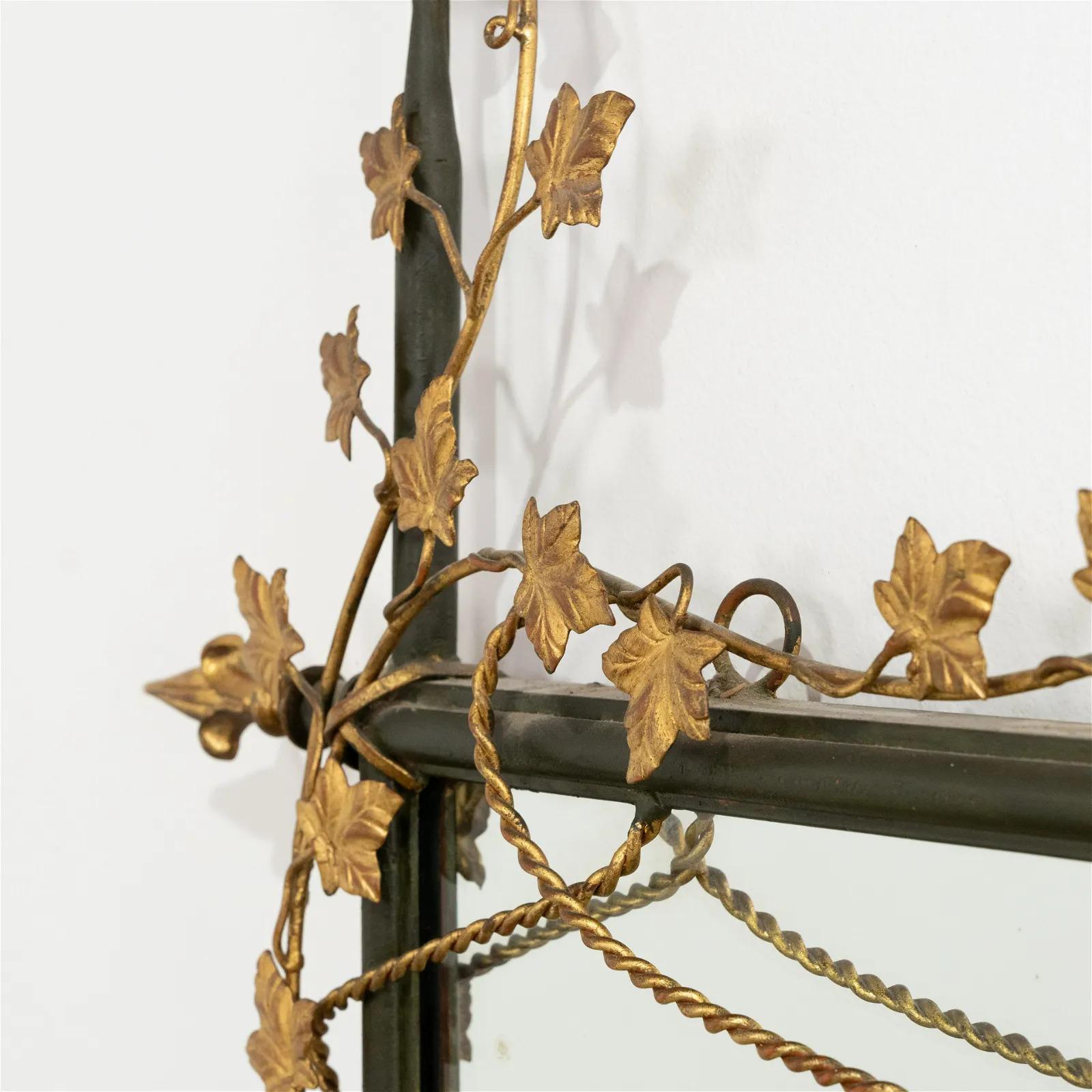 Grand miroir floral italien en métal doré. Le miroir a un cadre peint avec des arrangements floraux dorés. Style néoclassique.