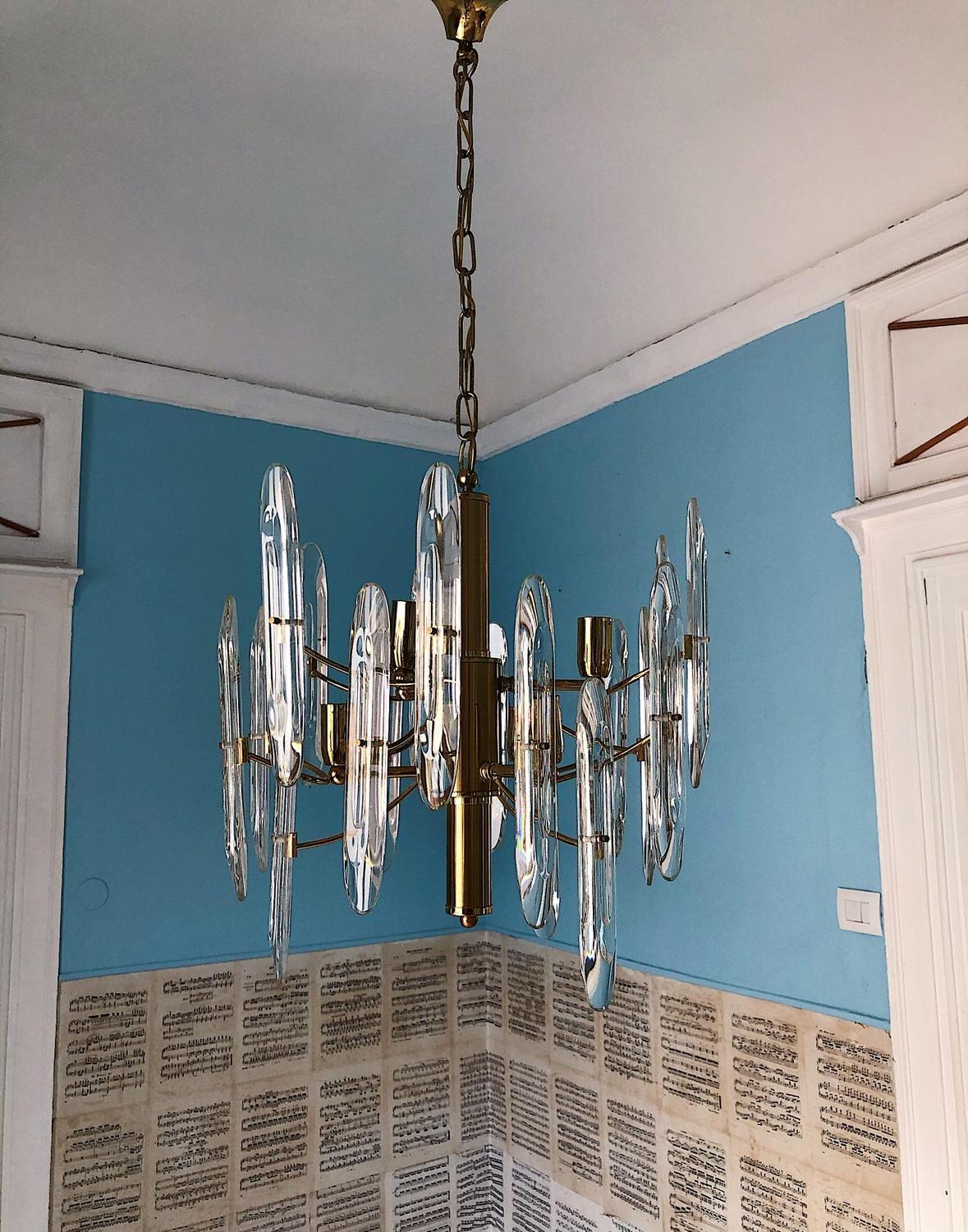 Gorgeous 6 armed chandelier by Gaetano Sciolari, 1970s, Italy.
18 crystal galsses set on a metal base. 6 Light bulbs.

Details
Creator: Gaetano Sciolari
Dimensions: Height whitout chain 50 cm Height with chain 100 cm Diameter 46 cm. The 18