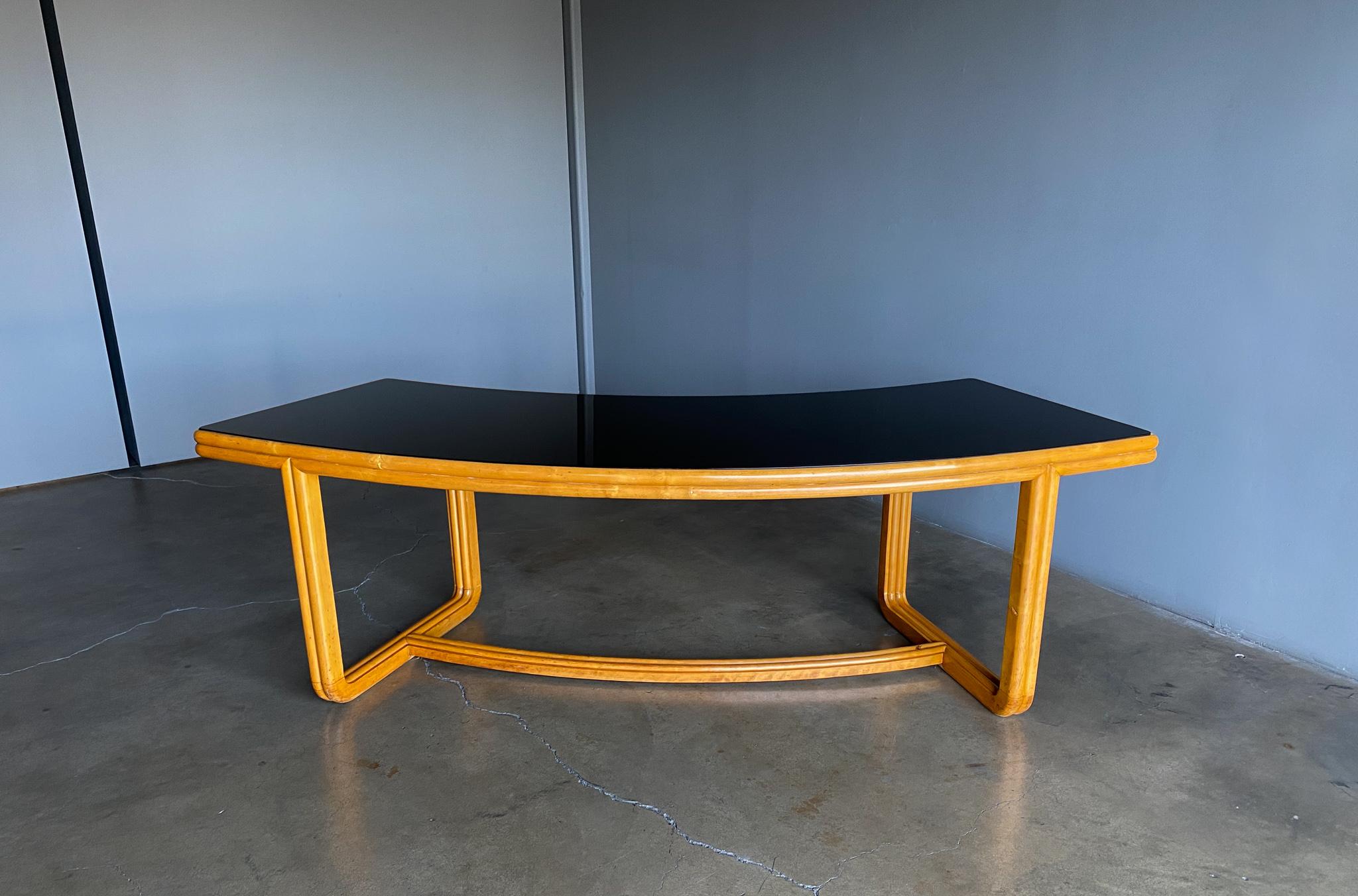 Italian large scale curved writing desk, circa 1955. Maple frame with a dark smoked glass top.