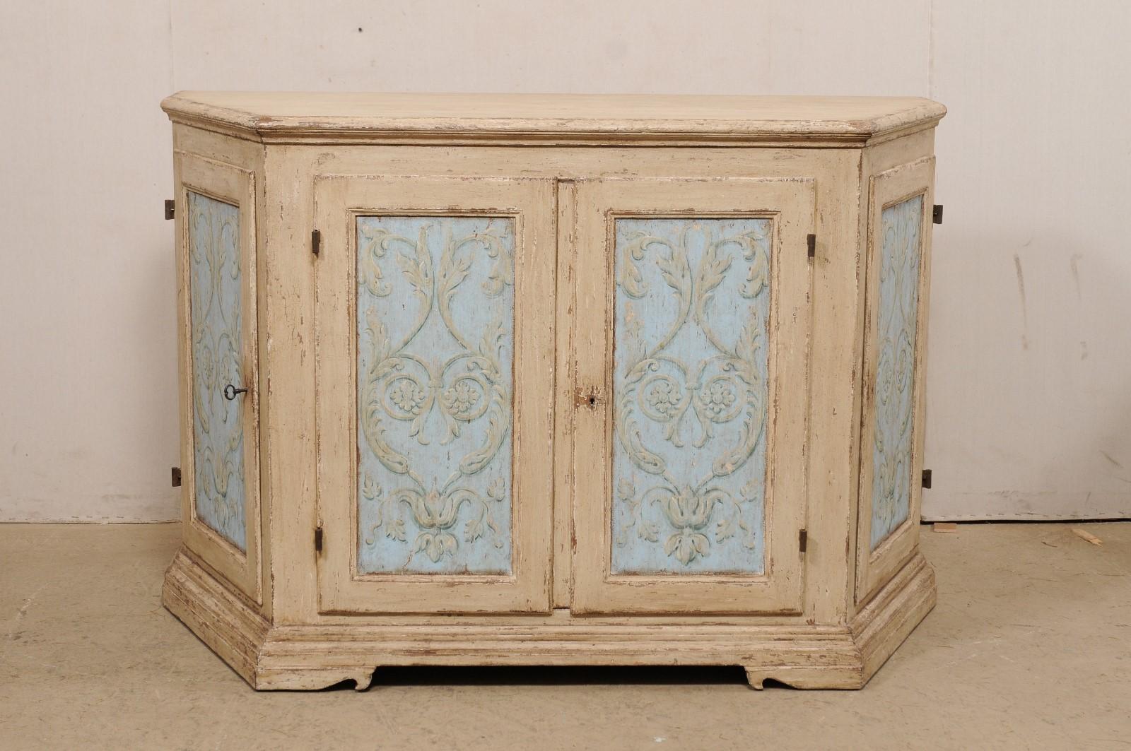 A vintage Italian large sized hand-painted wooden buffet cabinet. This Italian console cabinet is fitted with four doors, two at the shorter front side, flanked by a pair at the nicely canted sides. Each door is recess paneled, has been artistically