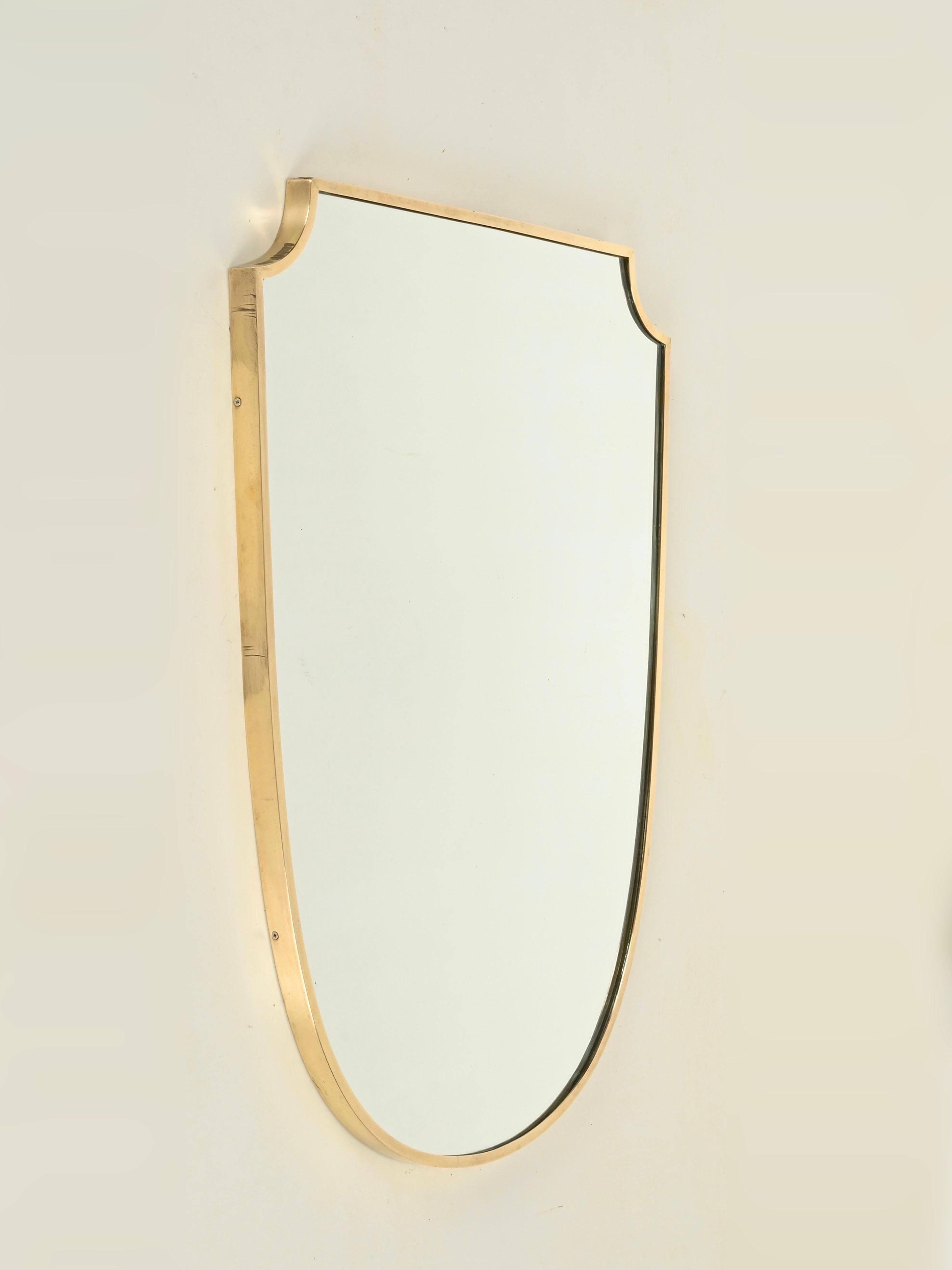 Splendido specchio a forma di scudo di grandi dimensioni con cornice in ottone massiccio. Questo pezzo incredibilmente elegante è stato prodotto in Italia negli anni '50 e il suo design è attribuito alla maestria di Gio Ponti.

Completamente