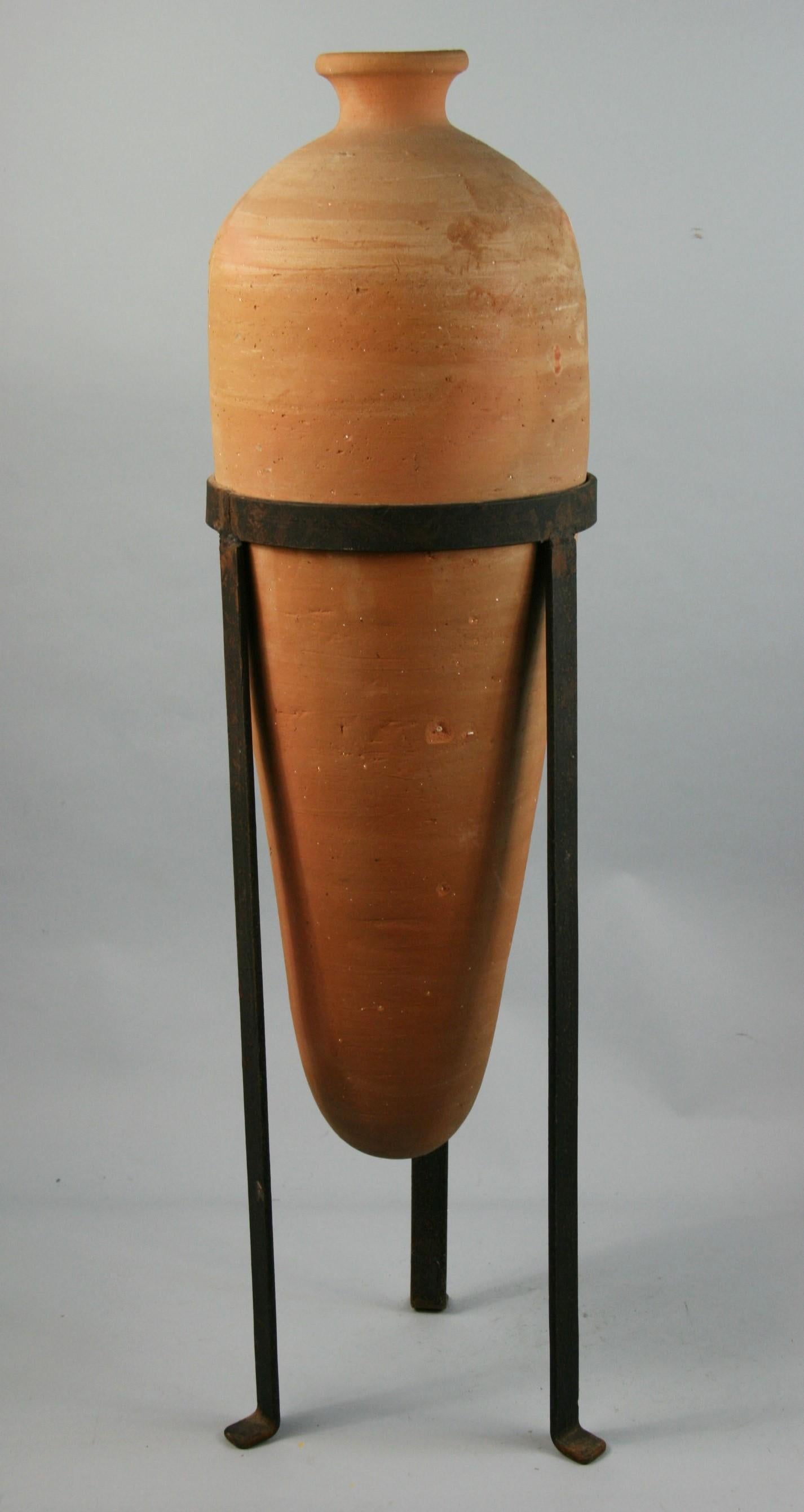 Italian terracotta urn in a custom iron base.