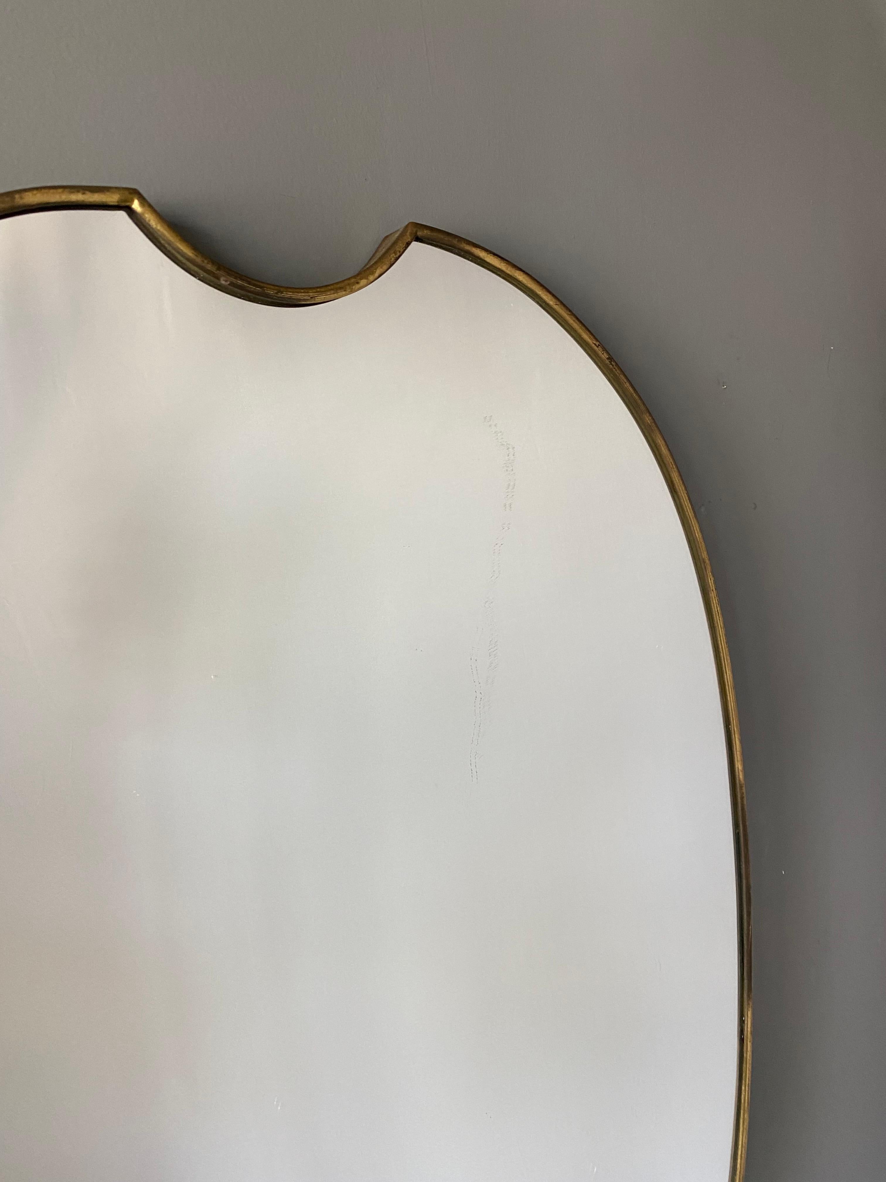 A large wall mirror, produced in Italy, 1940s-1950s. Cut mirror glass is framed in brass. 

Other designers of the period include Gio Ponti, Fontana Arte, Max Ingrand, Franco Albini, and Josef Frank.
