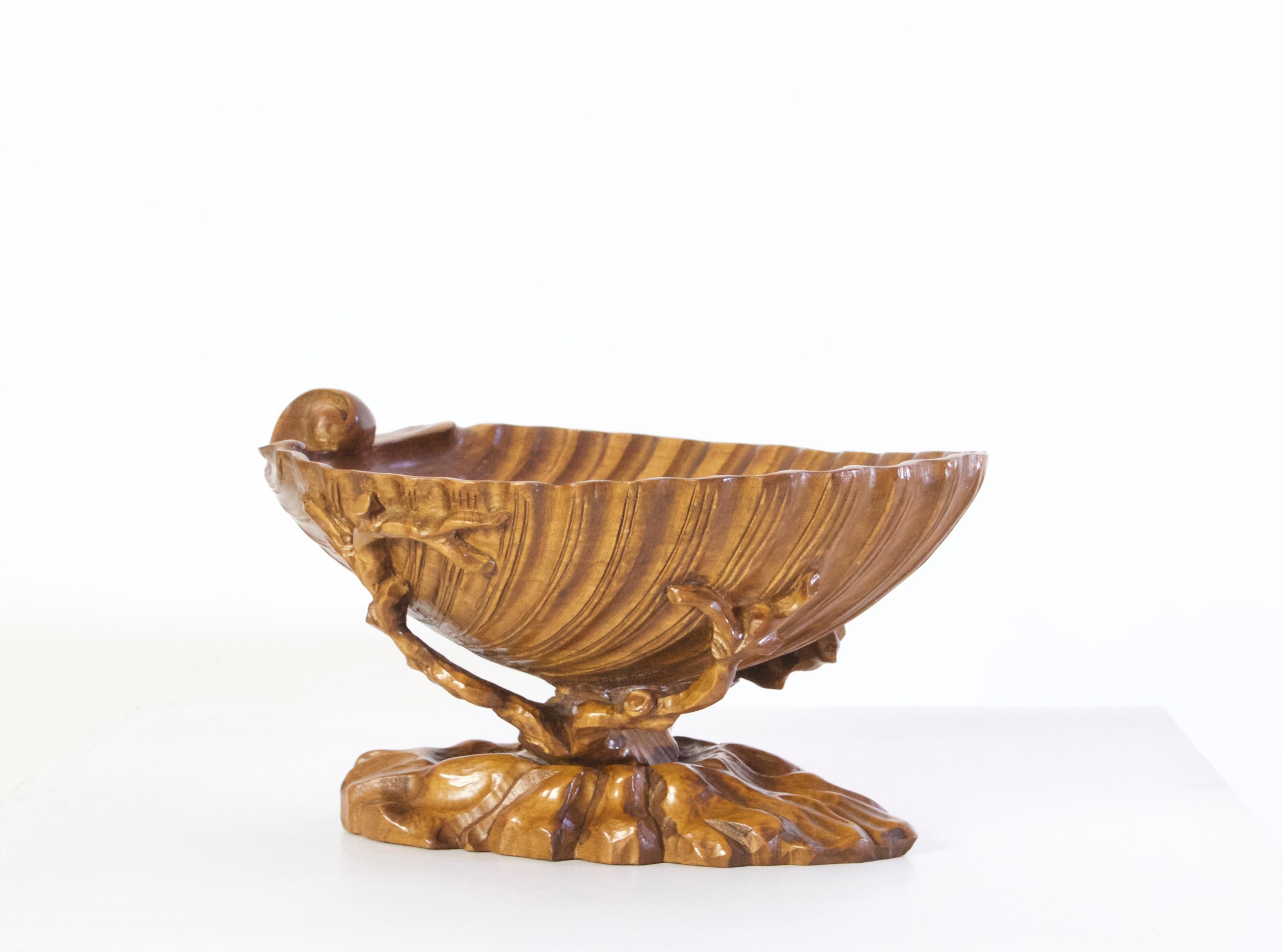 A large hand carved olive wood bowl in the shape of a clam shell. Great for decorative purposes or as a fruit bowl. No fading, chipping or cracks.