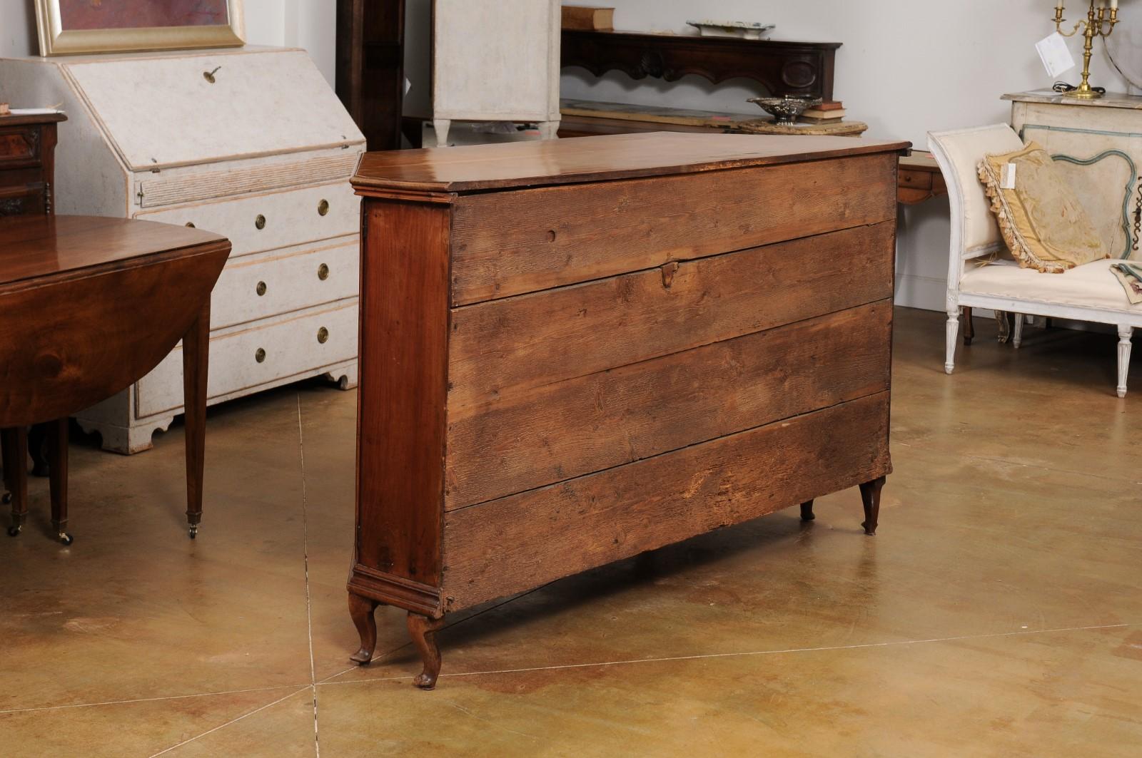 An Italian cherry sideboard from the late 18th century with four carved doors, canted corners and scrolling feet. Created in Italy during the later years of the 18th century, this cherry sideboard features a polygonal planked top sitting above a
