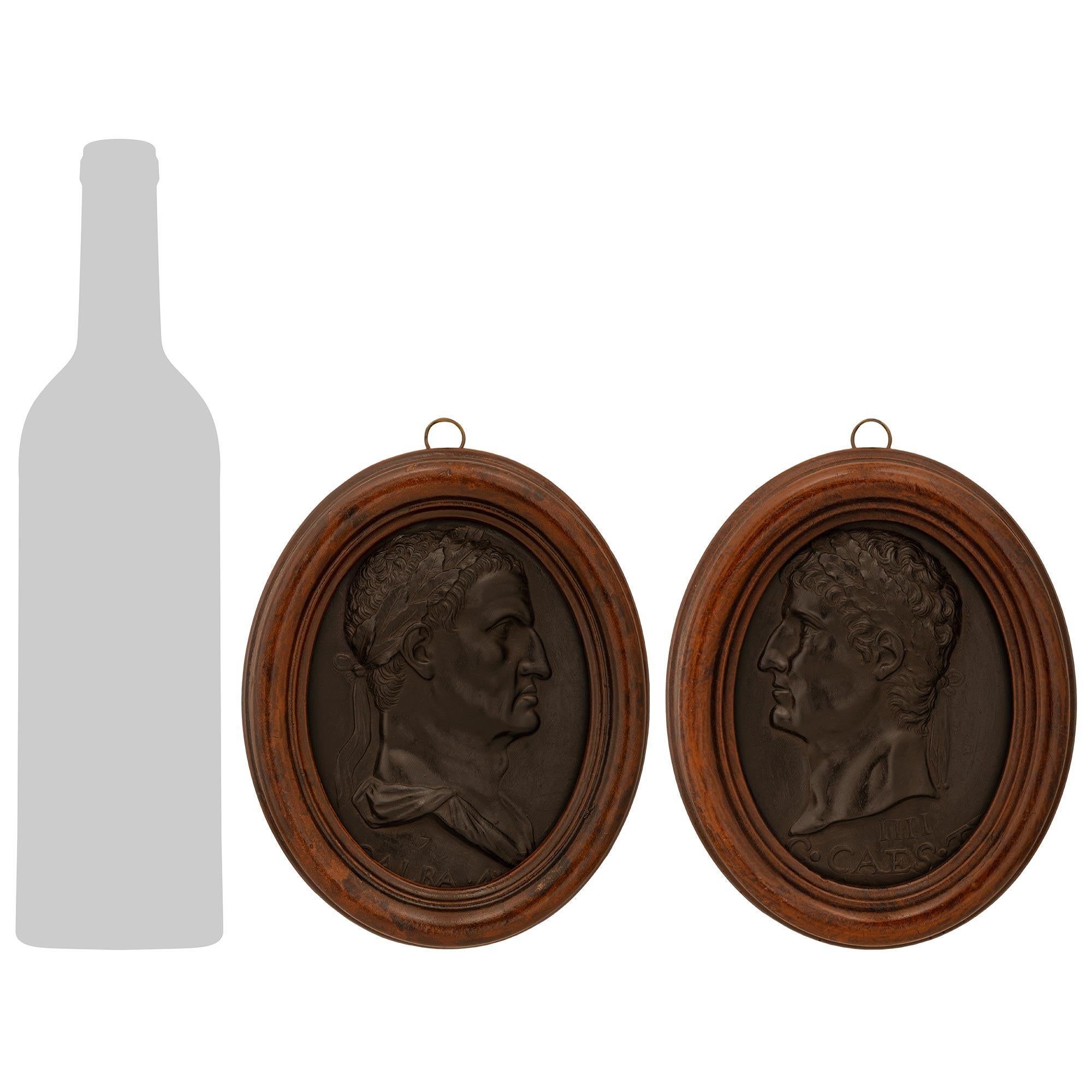 Bonita y muy decorativa pareja de placas italianas de madera de basalto de Wedgwood y madera patinada de finales del siglo XIX. Cada silueta, finamente detallada, identifica a un emperador romano en una placa de basalto de Wedgwood enmarcada dentro