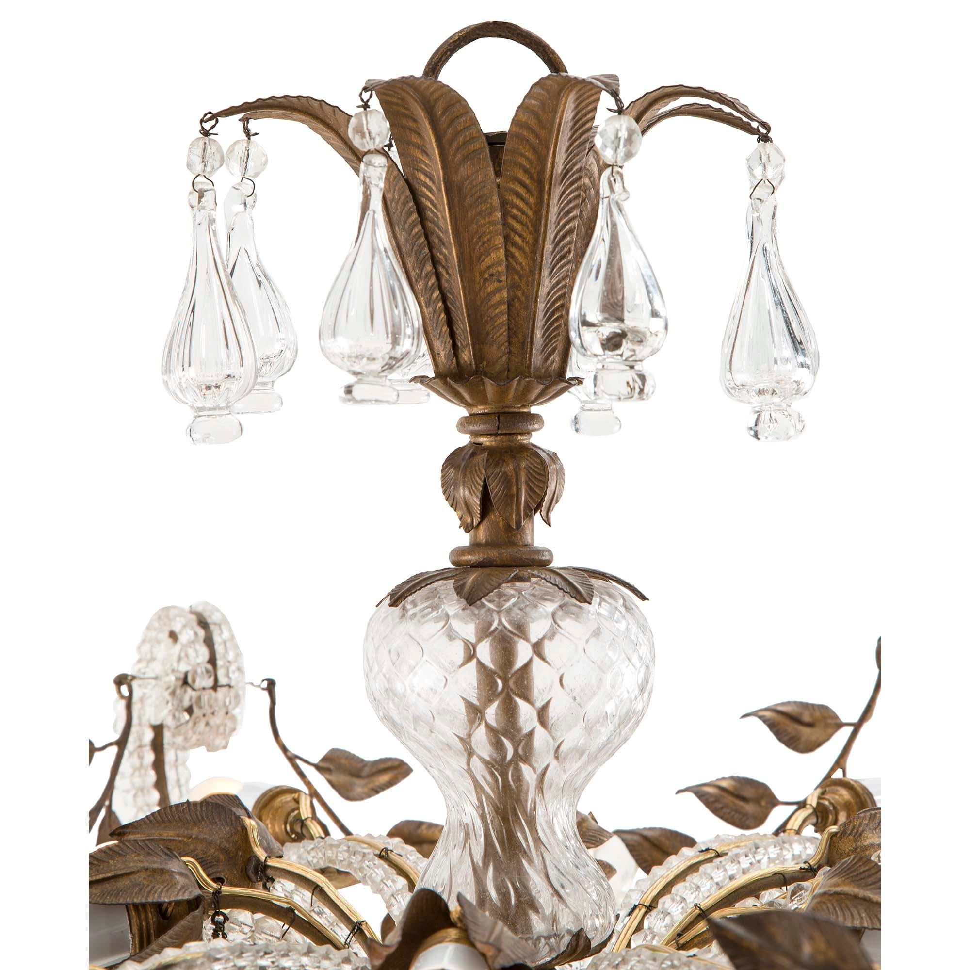 A very unique and attractive Italian late 19th century Louis XV st. glass and tole chandelier. This twelve light chandelier has a tole inverted blossom finial base with leaves and a central glass pendant. Six scrolled lighted arms are decorated with