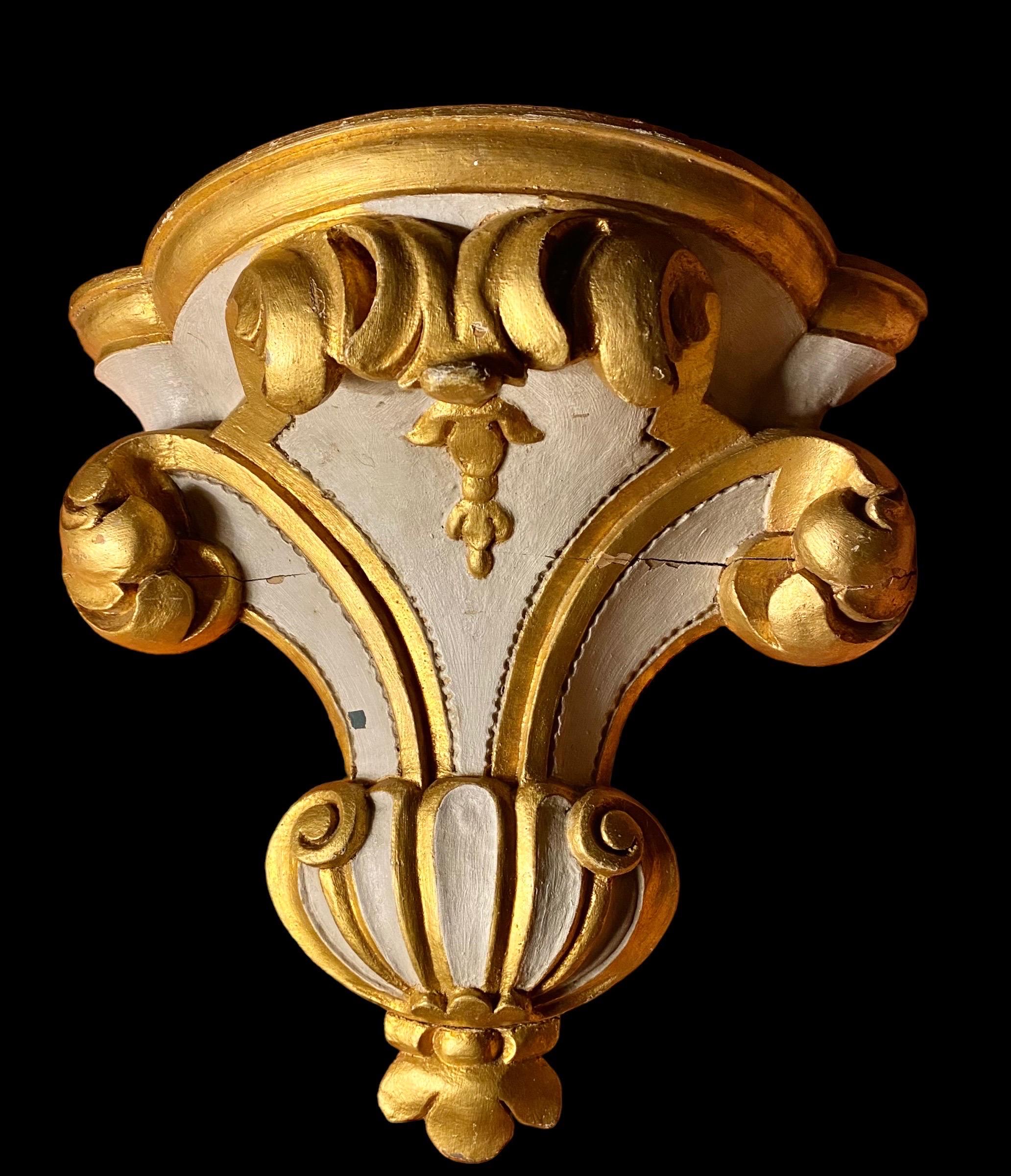 A 19th century Italian Painted and Parcel-Gilt Wall Bracket with fleur-de-lis and Acanthus Leaves.

This Italian architectural piece, from the late 19th century, has been hand-carved in a scroll and leaf motif. The Demilune shelf top has a beveled