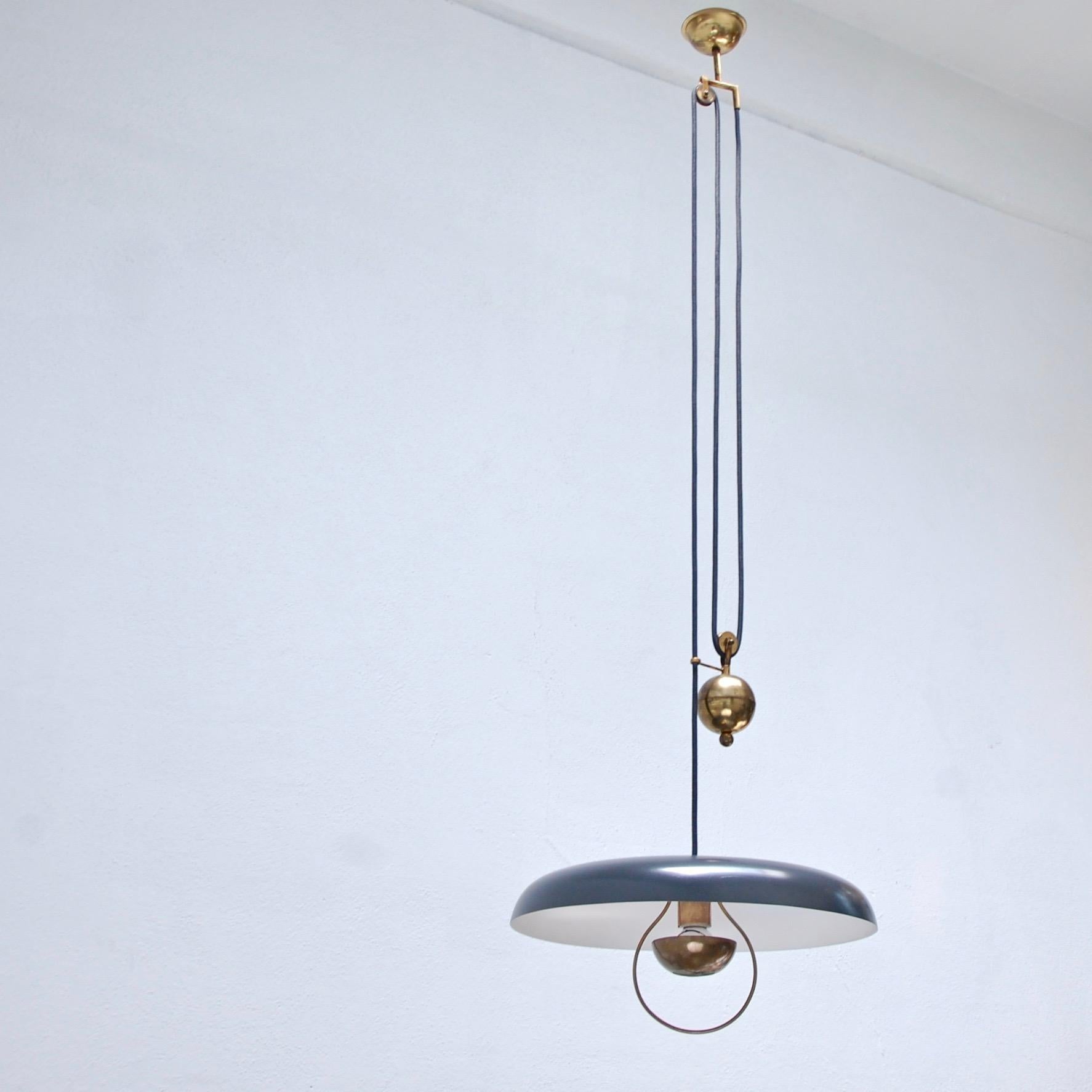 Italian late 1940s adjustable pulley pendant in naturally aged brass and painted aluminum. Partially restored. Height is adjustable due to pulley feature. Light bulb included with order. 
Measurements:
Fixture height: 8”
Diameter: 18”
OAD: