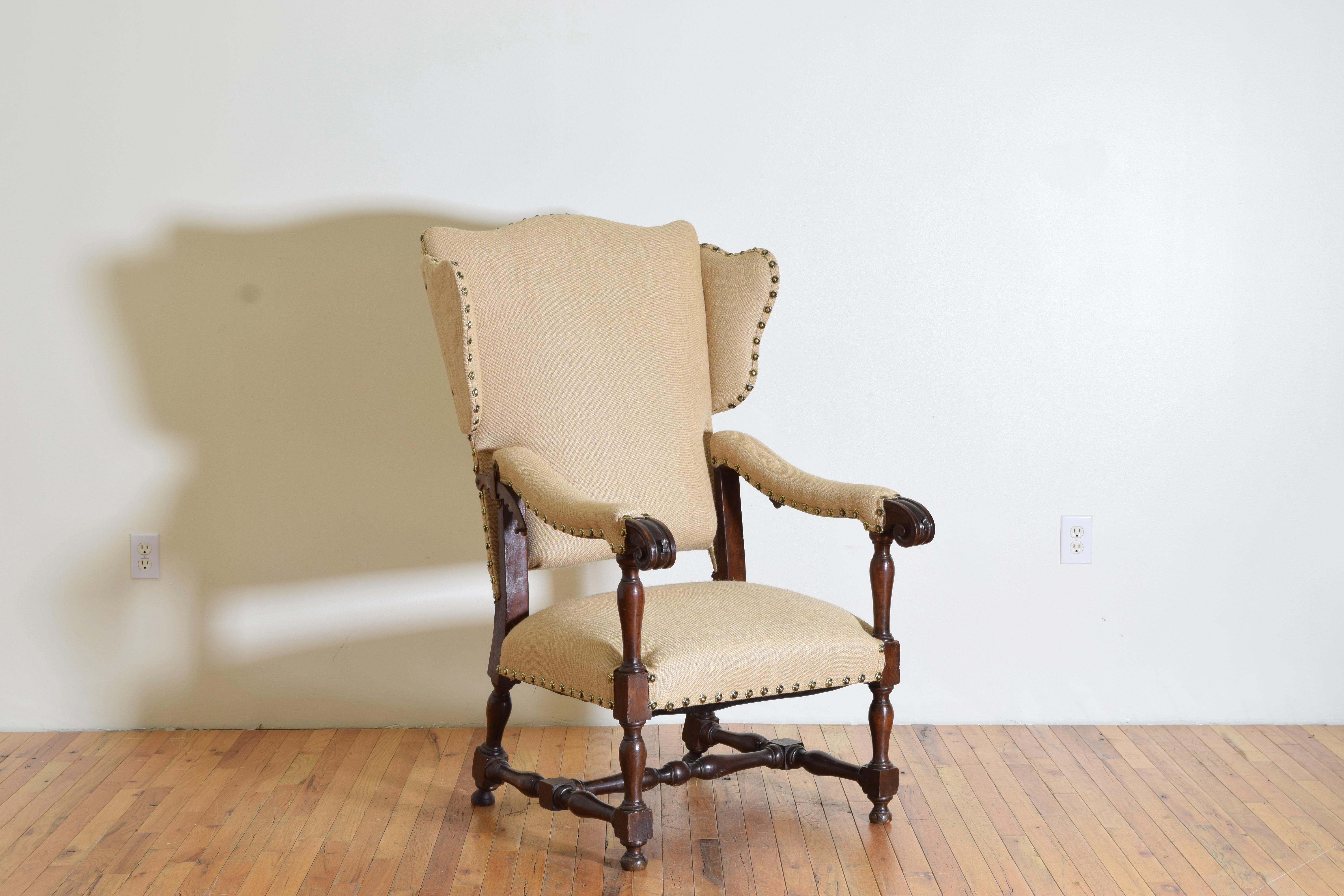 Having an arched backrest with flared wings, long descending arms with carved handles and raised-on-turn supports, handles issuing iron rods with shell-shaped finials used to support a tray, the backrest fitted with gilt iron ratchets for multiple