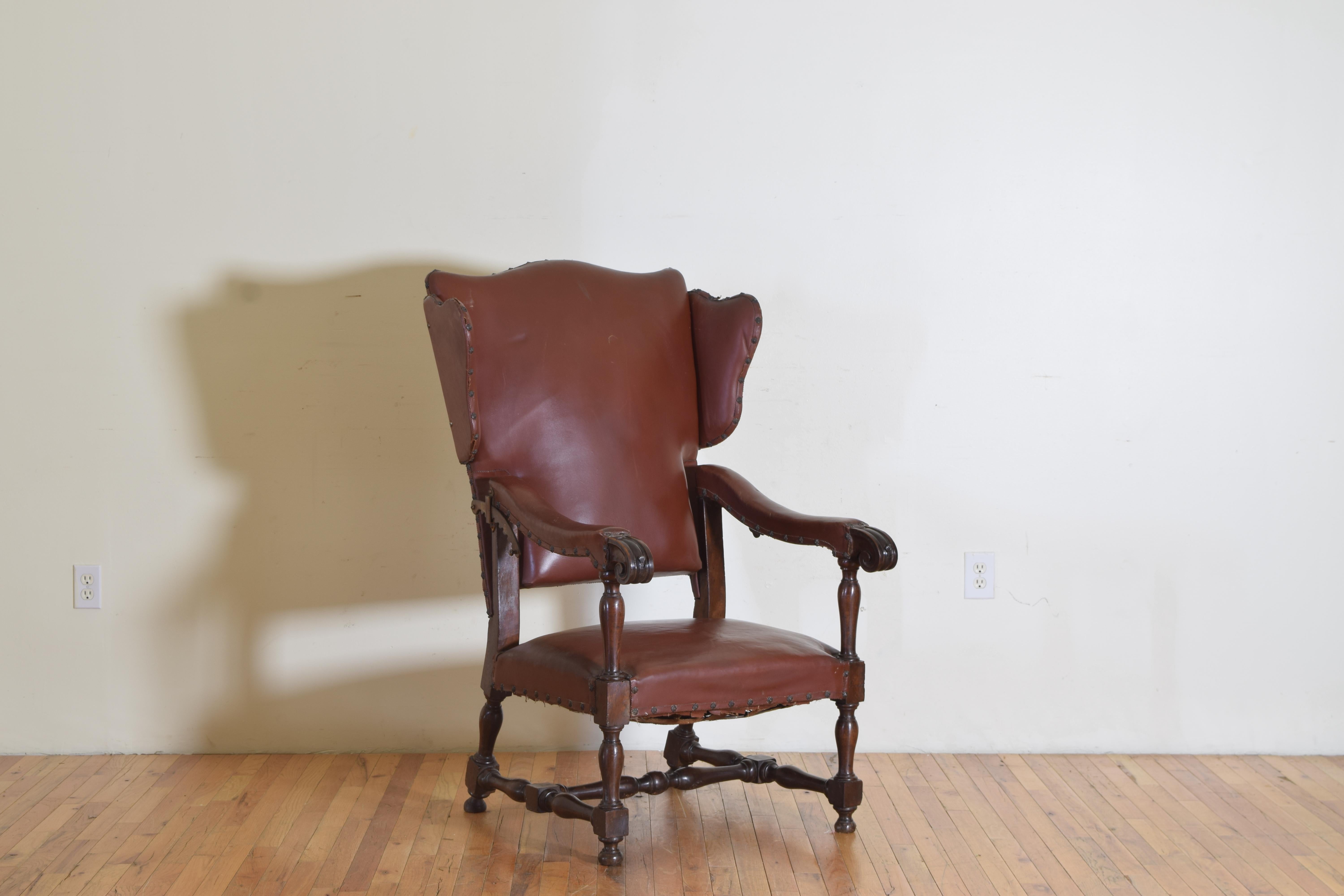 Having an arched backrest with flared wings, the long descending arms with carved handles and raised on turned supports, the handles issuing iron rods with shell shaped finials used to support a tray, the backrest fitted with gilt iron ratchets for