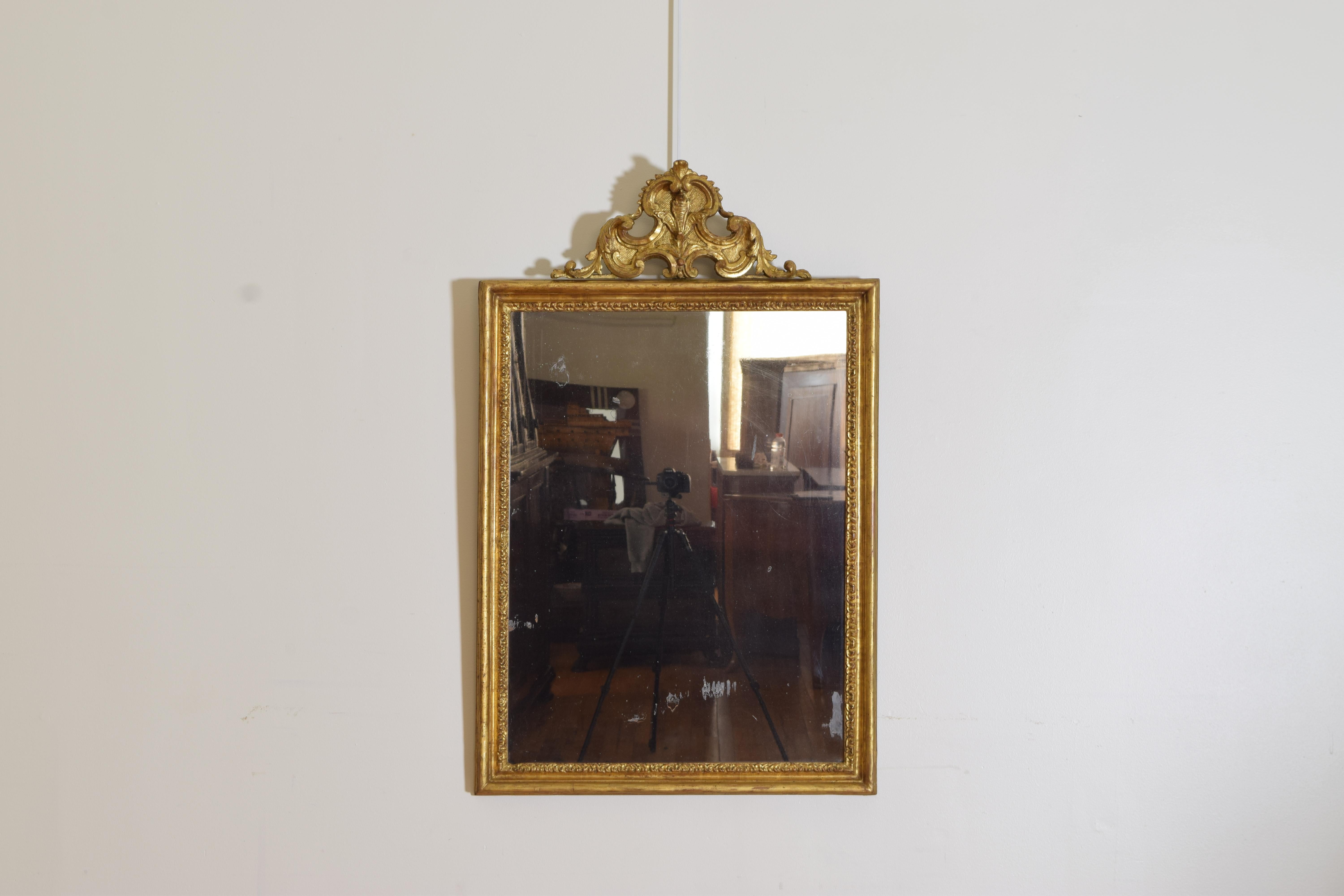 Of rectangular form with scroll carved and punchwork moldings this mirror also has a prominent pediment in cartouche form, in beautifully restored condition, retains antique mirrorplate.