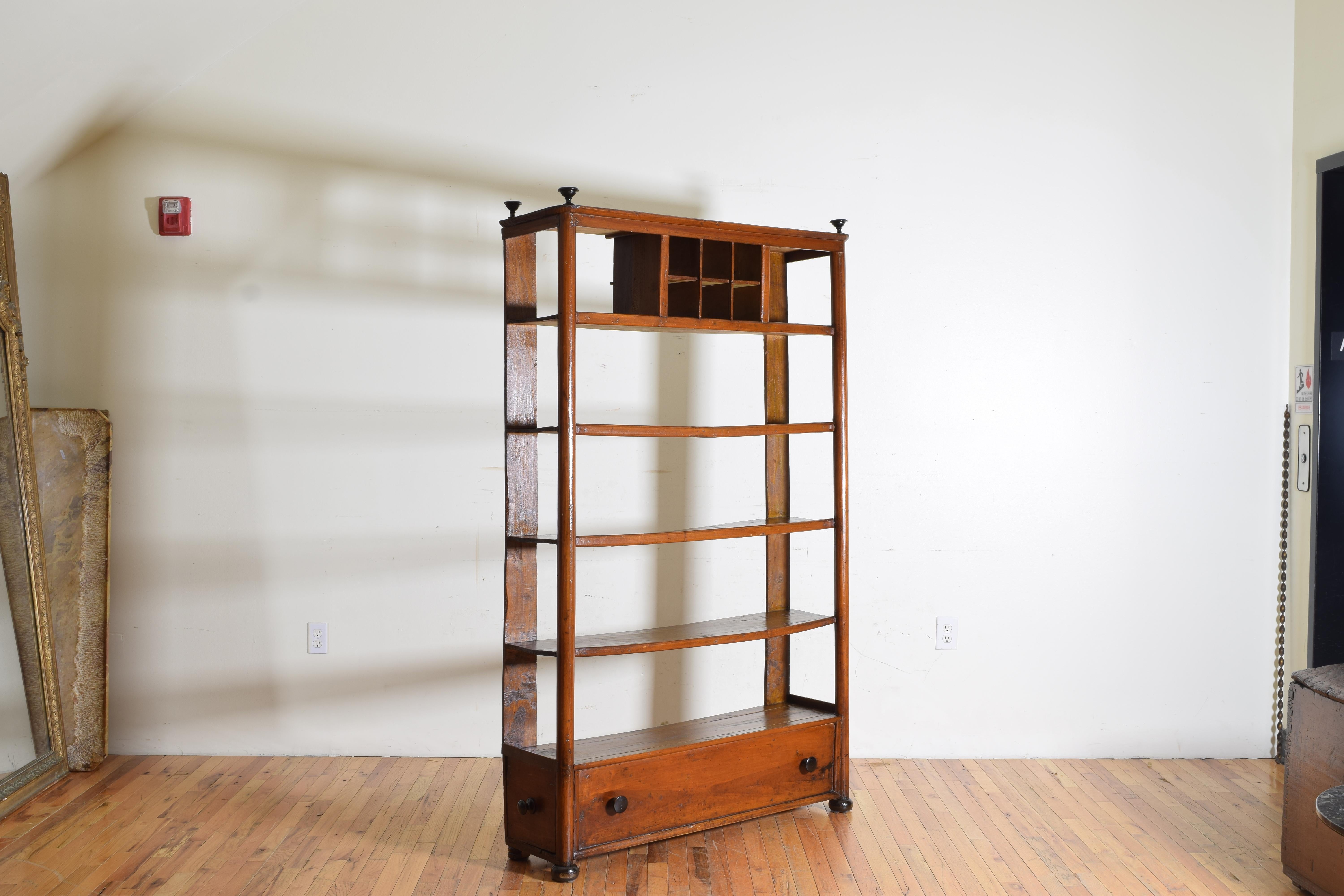 Having front columns and flat rear supports all topped with small ebonized urns, with five levels, the upper with a 6 section divider, the lowest section with a faux front accessed by two side drawers all with ebonized pulls, raised on ebonized