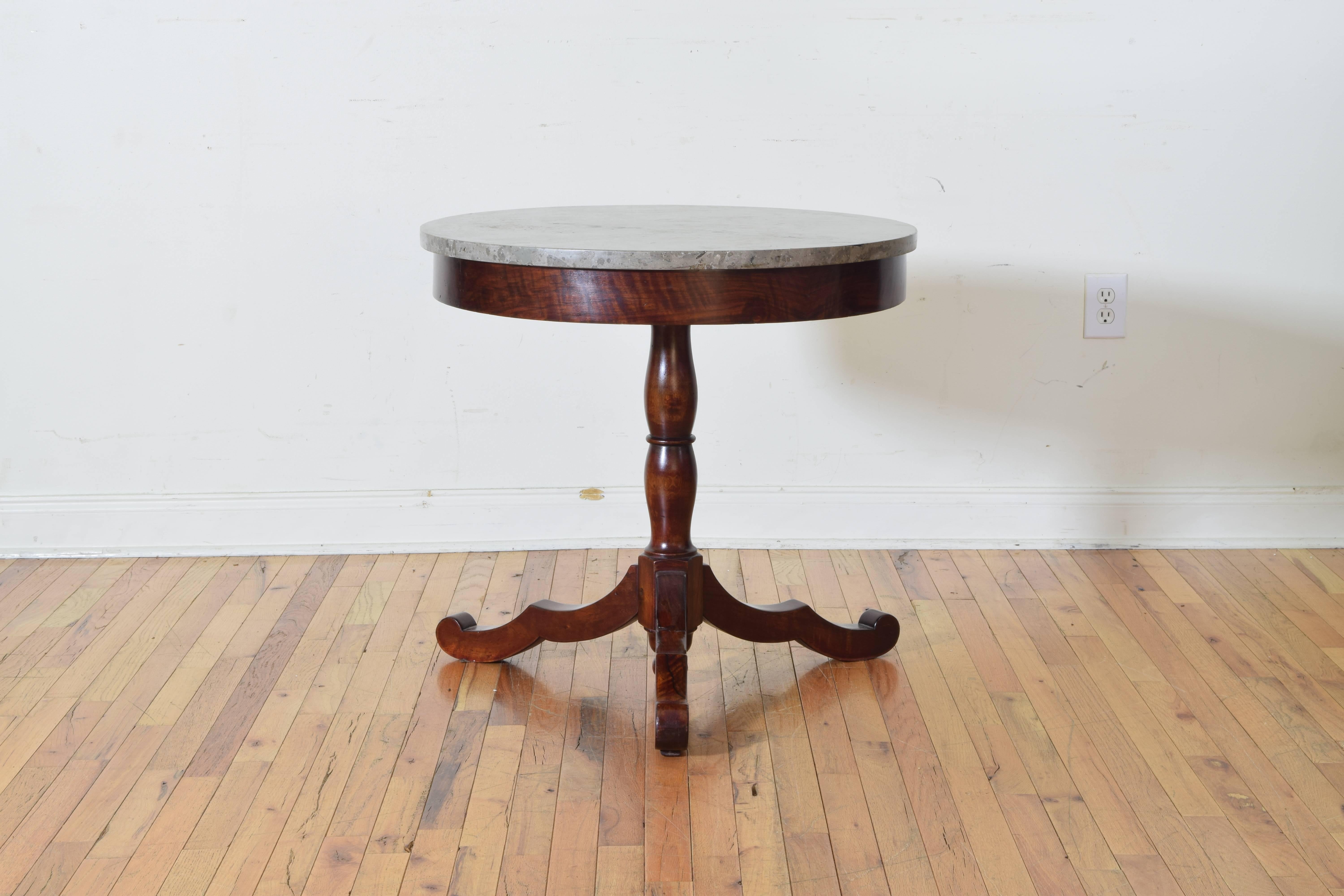 The circular grey marble top resting atop a conforming frame and supported by a turned column above a tripartite base issuing three curved and widely splayed legs.