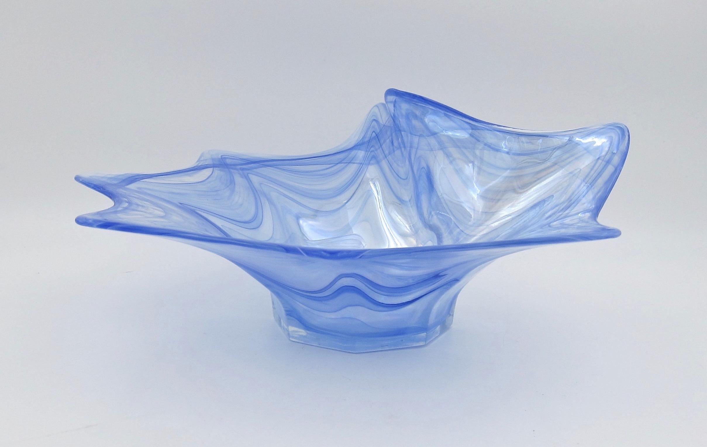 An Italian art glass bowl flaring up and outward from a molded hexagonal foot. The sculptural bowl of clear glass has pulled blue threads throughout with golden iridescent highlights. The profile and color of the bowl resemble a splashing drop of