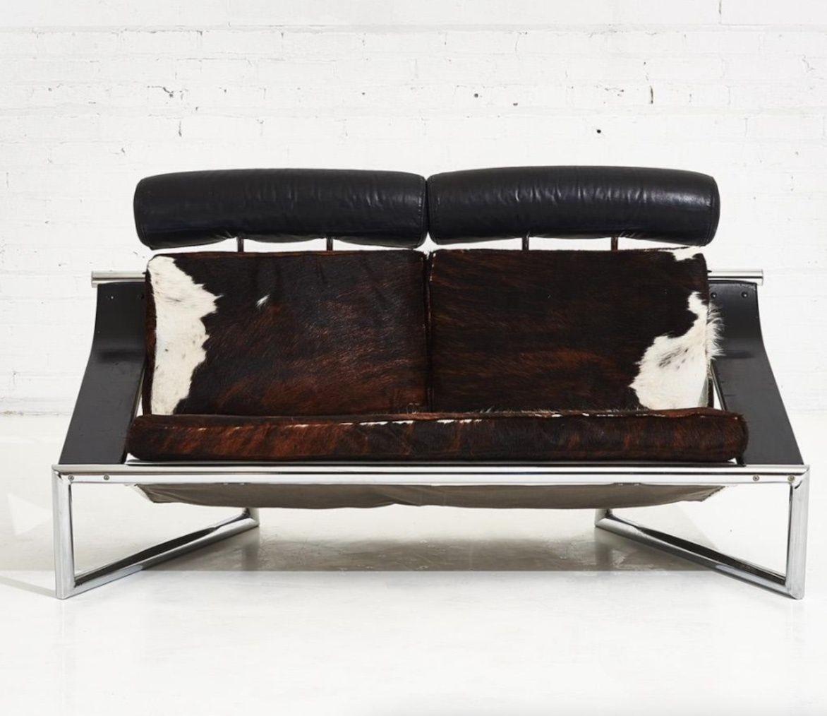 Italian leather and chrome settee adjustable headrests. Hair on hide leather, angular chrome frame, black enameled arms. Original.