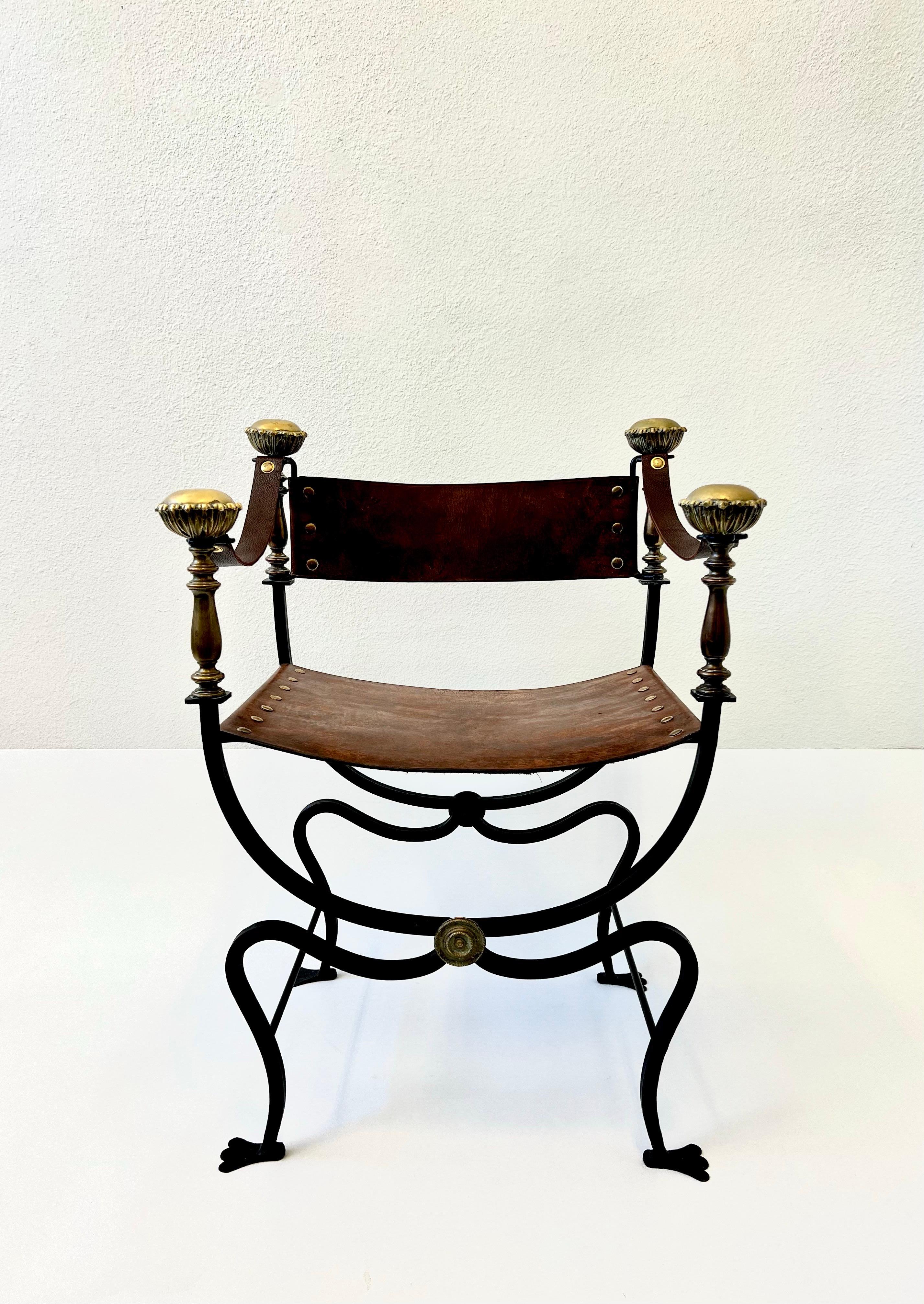 Italian black iron and leather with brass details Campaign chair from the 1960’s. 

The frame is constructed of black lacquered forged steel with decorative brass details, the seat, back and arm rests are leather. The leather on the arm rests is