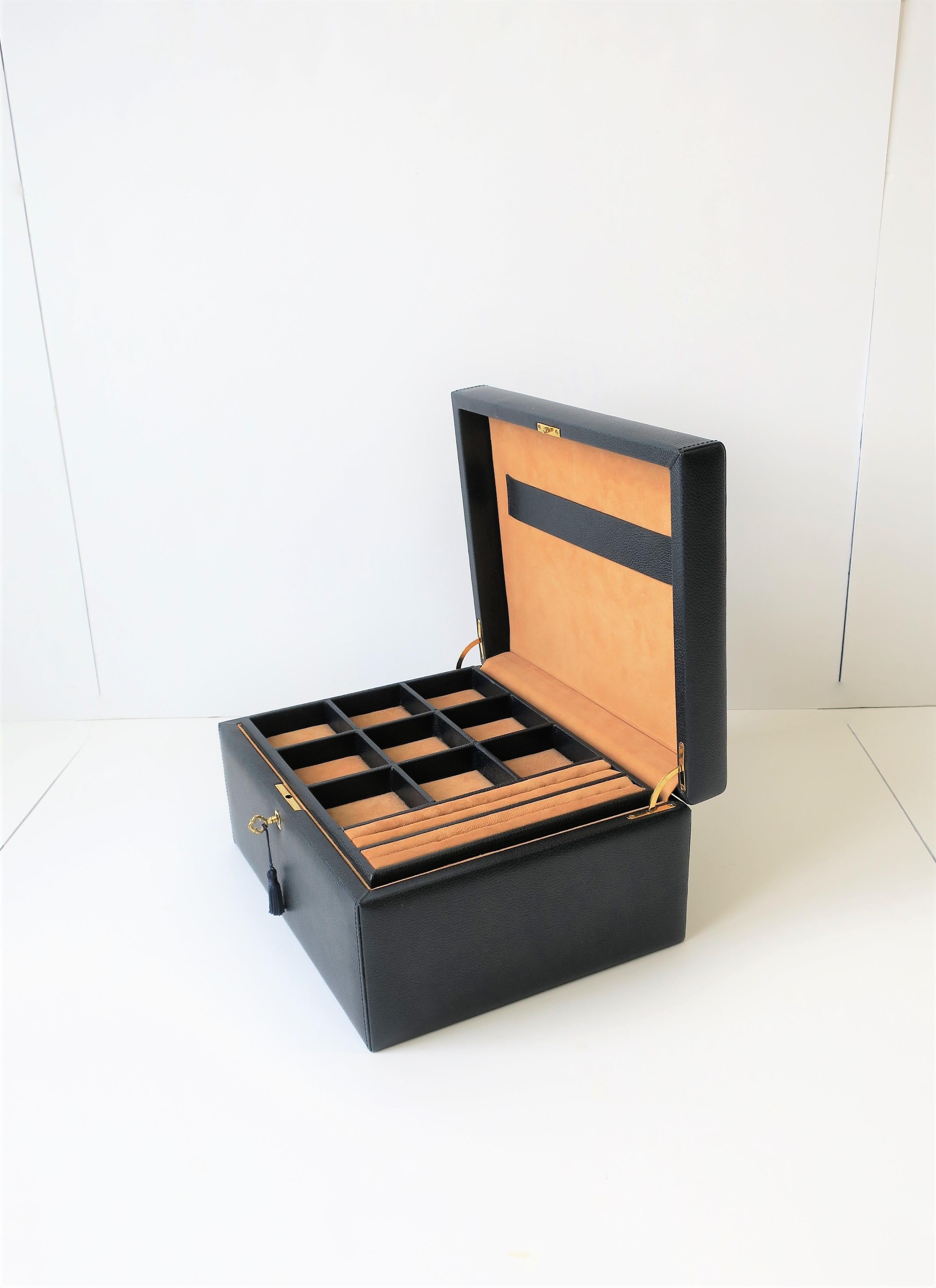 A beautiful Italian leather and suede jewelry box with brass key or lock, Italy, circa 21st century. Box has a dark blue leather exterior and a tan suede interior, with a brass key or lock with dark blue tassel. Box has an inside storage base area,