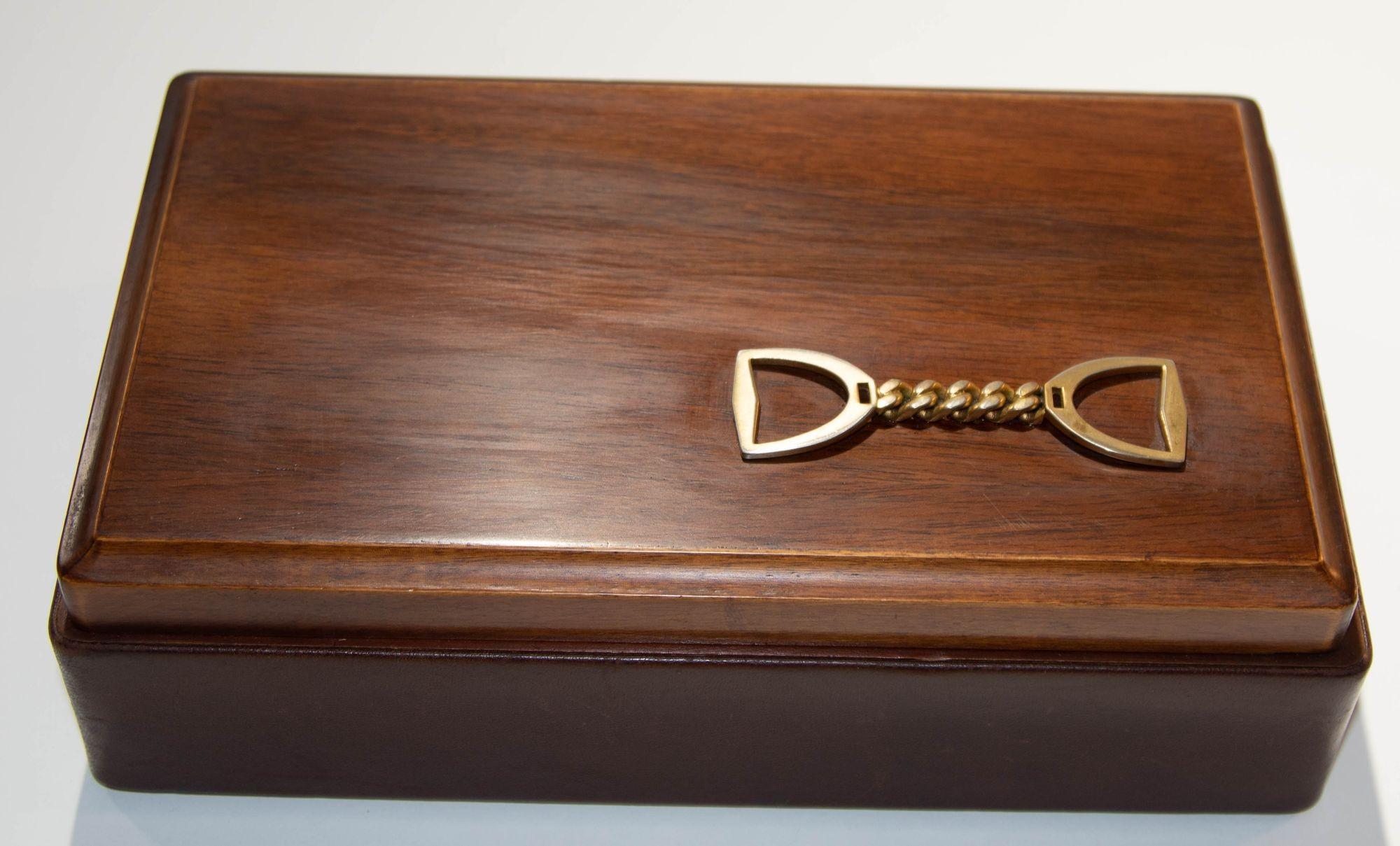 Vintage Italian Leather and Wood Jewelry Vanity Box with Horse Stirrup Brass Chain.
Bottom box wrapped in venetian leather, felt bottom, marked made in Italy.
Top cover in wood with a decorative stirrup horse brass chain in Gucci style.
Interior in